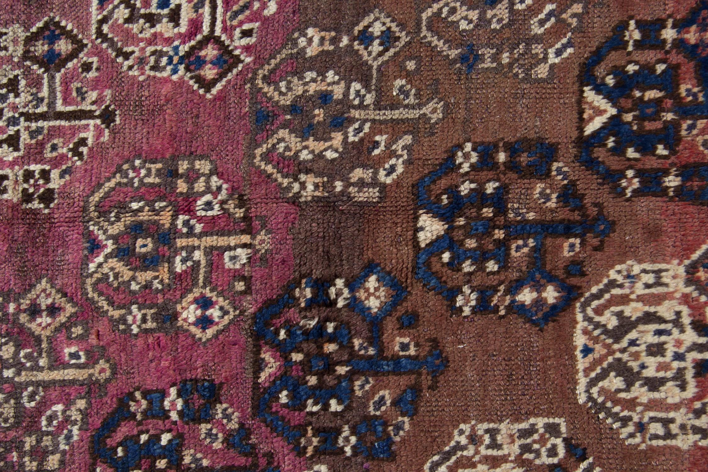 A remarkable Paisley pattern decorates the background of this beautiful rug. Blue, cream and brown make up the fantastic Tree motifs woven on a pink and rust background. The charming central design is enclosed by a highly-detailed border, featuring