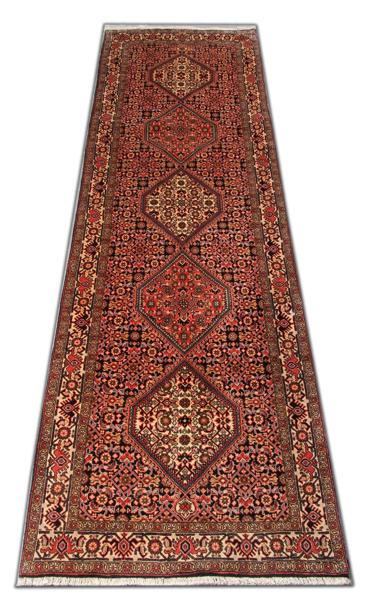 This elegant wool runner rug was handwoven in the 1970s and features a fantastic diamond medallion with an intricate motif surrounding the design. This is then framed by a delicate repeat pattern border. This stylish piece is the perfect accent