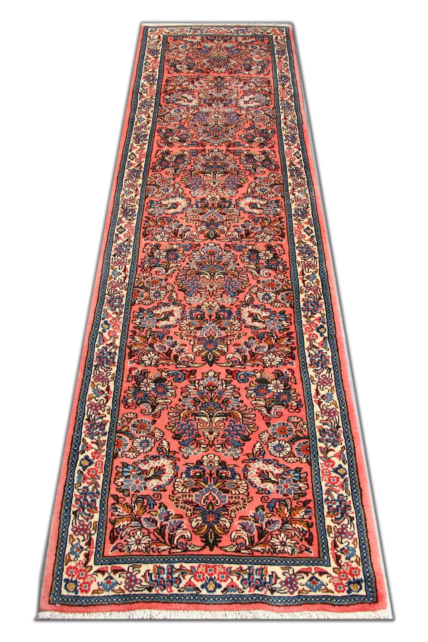 Dieser feine rosa Teppich ist ein traditioneller handgewebter Wollteppich aus den 1950er Jahren. Das zentrale Muster wurde auf einem satten rosa Hintergrund mit blauen, beigen und elfenbeinfarbenen Akzenten kunstvoll gewebt. Dieses wird dann von