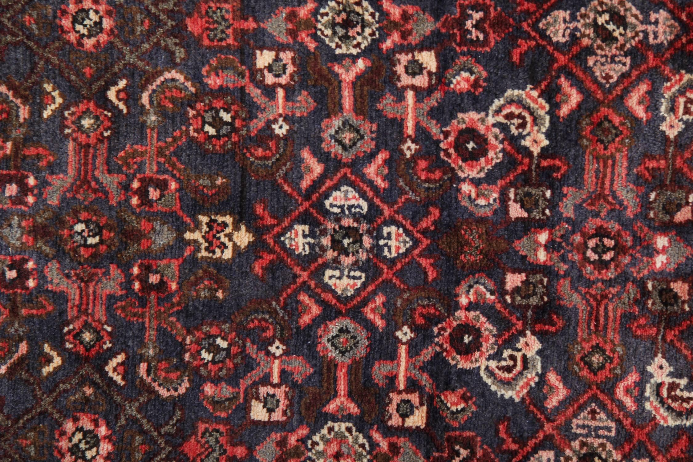Tribal motifs have been intricately woven into this fine wool rug, constructed in the 1950s. This piece features a highly decorative central design and the border with a dark blue background and contrasting red, beige and cream accent colours. 
The