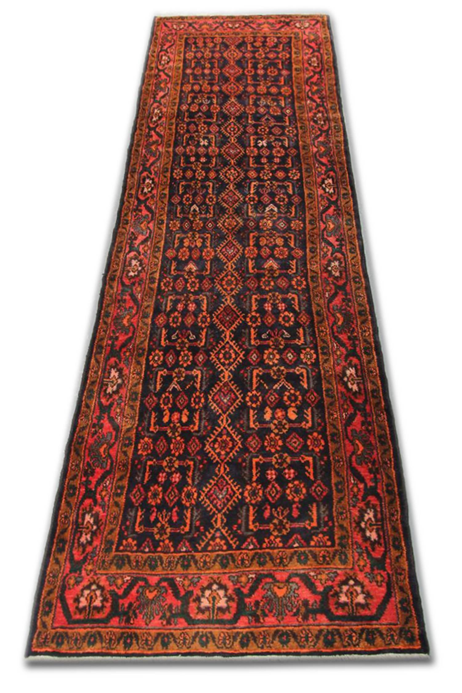 Traditional Oriental runner rug, handwoven wool carpet runner.
This elegant wool runner rug was woven by hand in the 1950s. The central design has been intricately woven with diamonds and motifs symmetrically placed on dark background in colors of