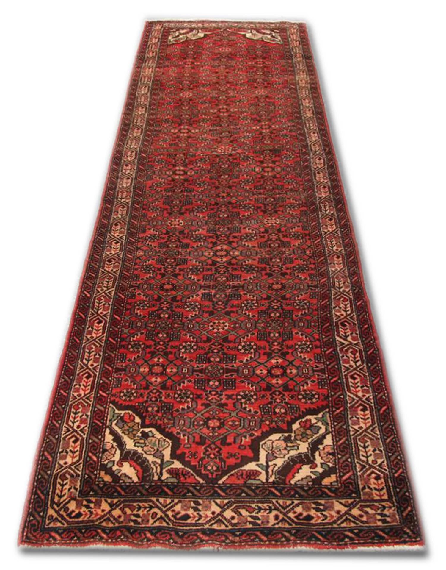 This wool rug is a fine example of traditional Runner Rugs from 1950. Featuring a red background that has been intricately woven with a symmetrical geometric pattern in contrasting colours of grey-brown and ivory. 
This rug would make a perfect