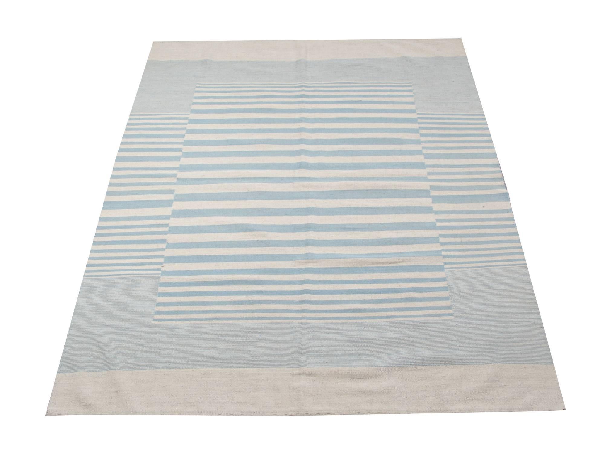 This striped rug is 100% handmade in Afghanistan. Kilim rugs are flat woven. The materials used for these handmade rugs are wool and cotton. Only organic dyes were used for these luxury rugs. This light blue rug is hard-wearing and therefore will