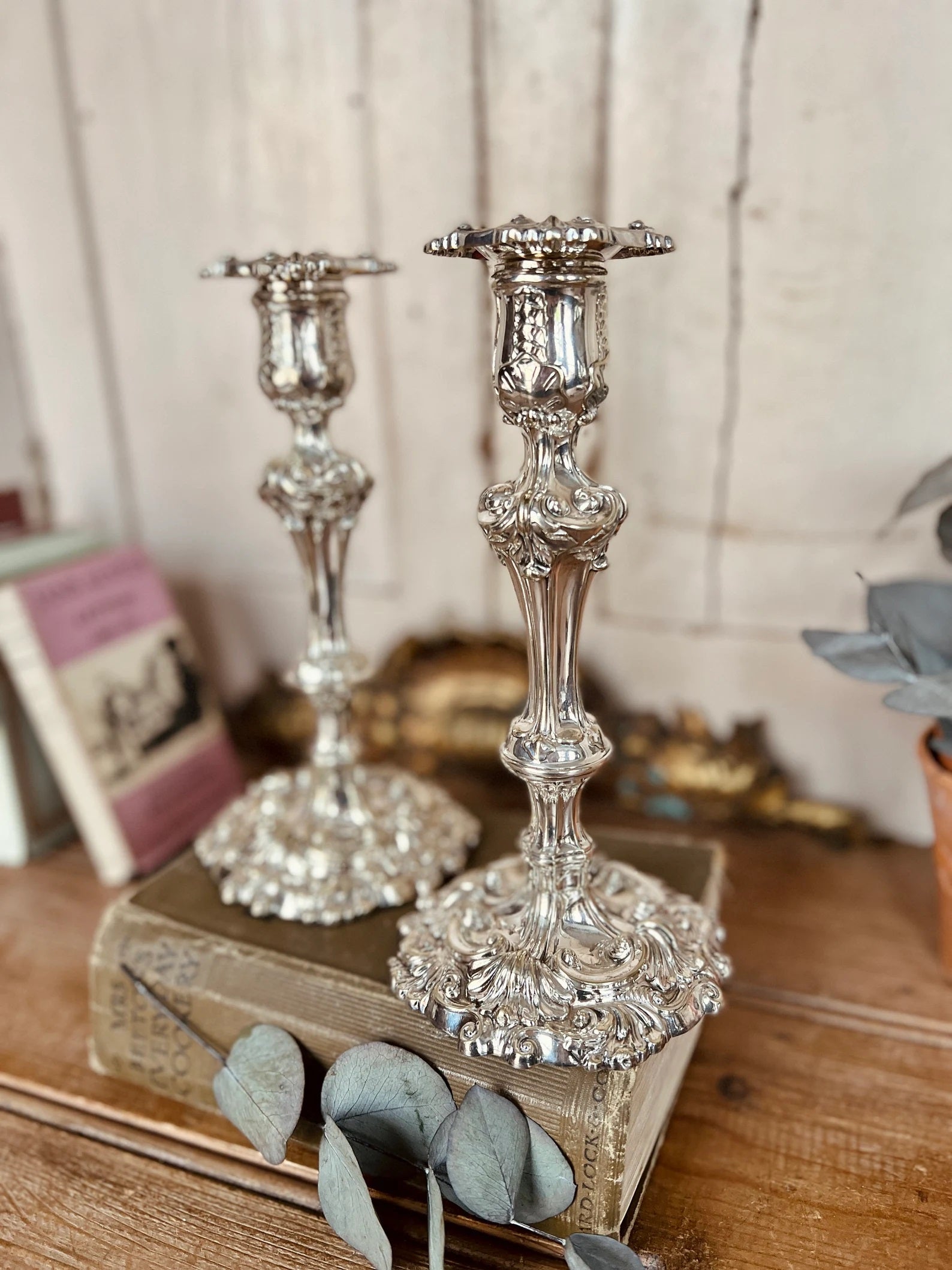 Antique silver, a pair of Rococo-style silver candlesticks, pressed, cast and chased. Circular, curved feet with hinged. This pair of large antique silver candlesticks was made in the early 19th century and is a hugely impressive example from the