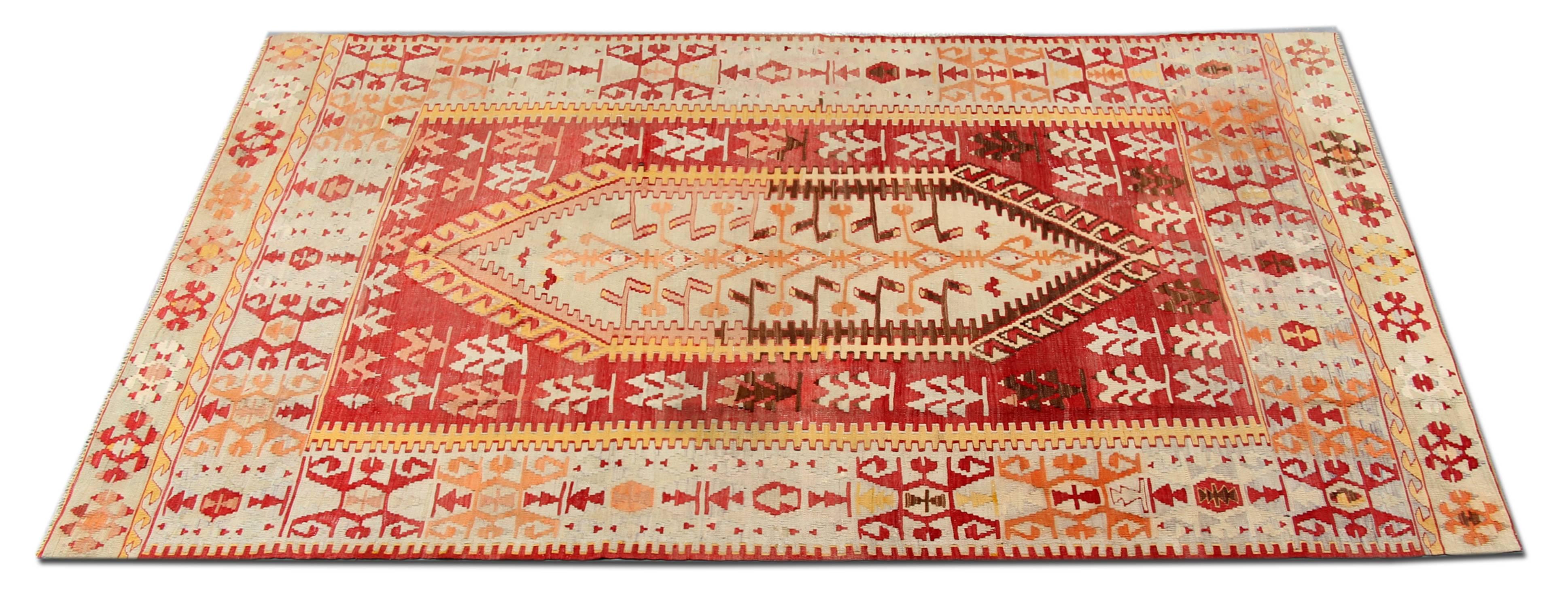This Red Rug is Anatolian flat-weave rug has red, yellow, orange, white and brown colors. This Floor rug has a wide red border with repeating patterns on it. Turkish carpets would complement your home as living room rugs. These patterned rugs look