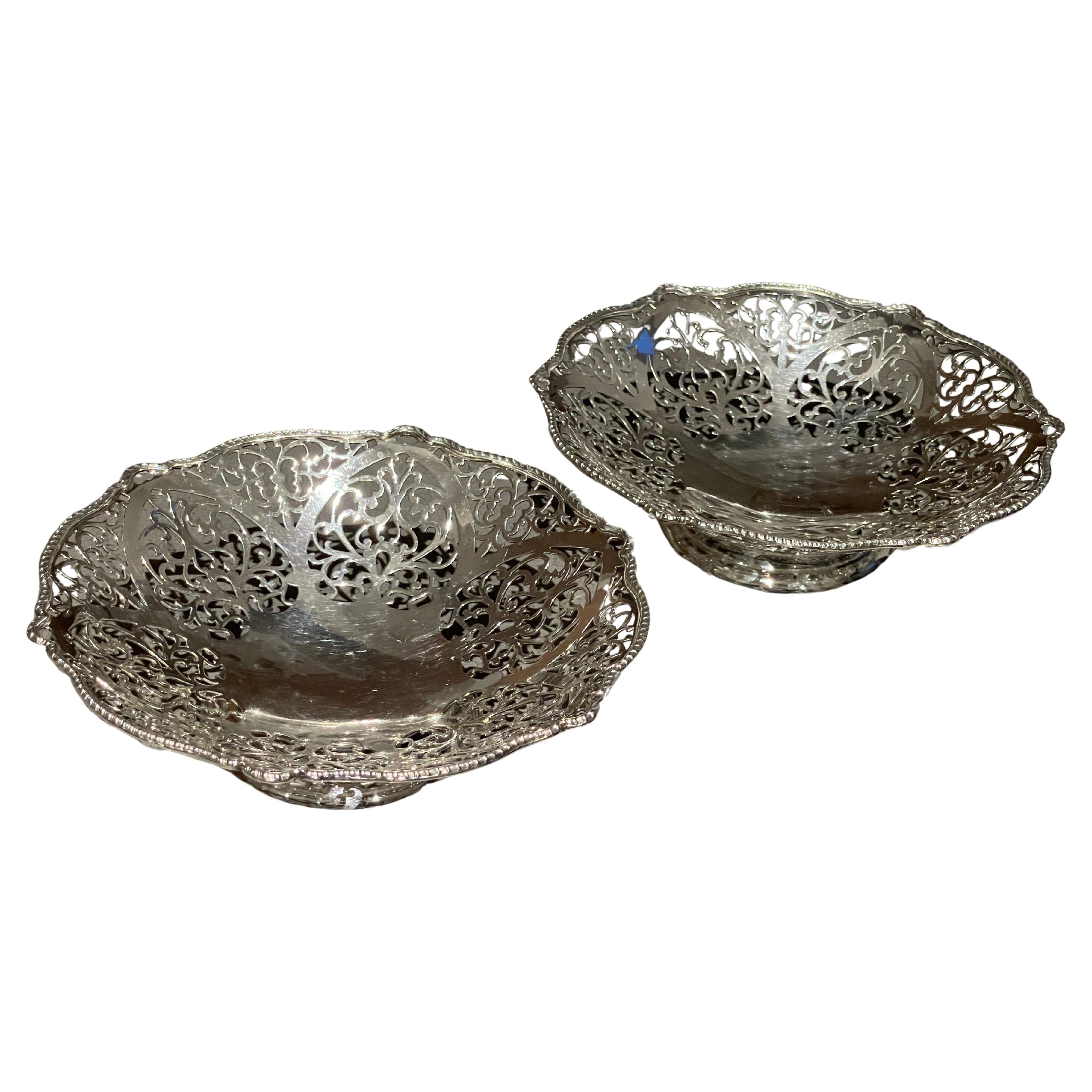 Un cesto di frutta antico placcato in argento di ottima fattura, caratterizzato da un elegante bordo traforato a galleria e da un manico oscillante a corda finemente dettagliato. La forma ovale poggia saldamente su un piede rialzato, offrendo