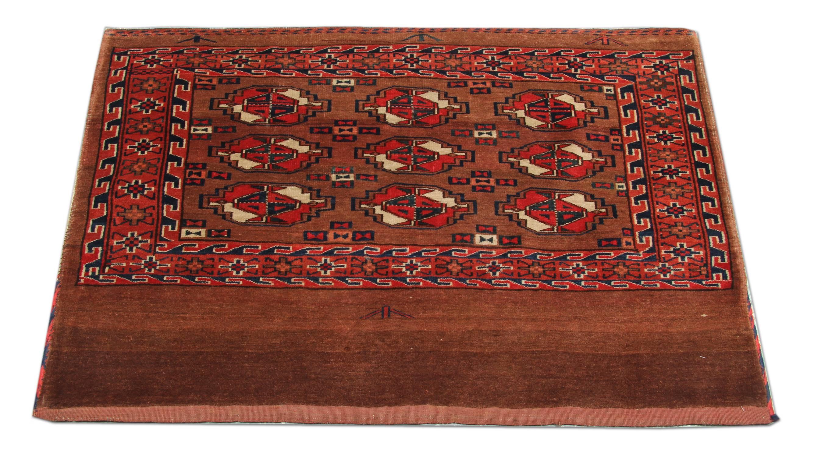 This elegant red wool rug is an excellent example of Afghan rugs woven in the 1890s. The design features a beautiful geometric pattern made up of circular motifs woven in beige, cream and black accents. A wonderful complimentary geometric border