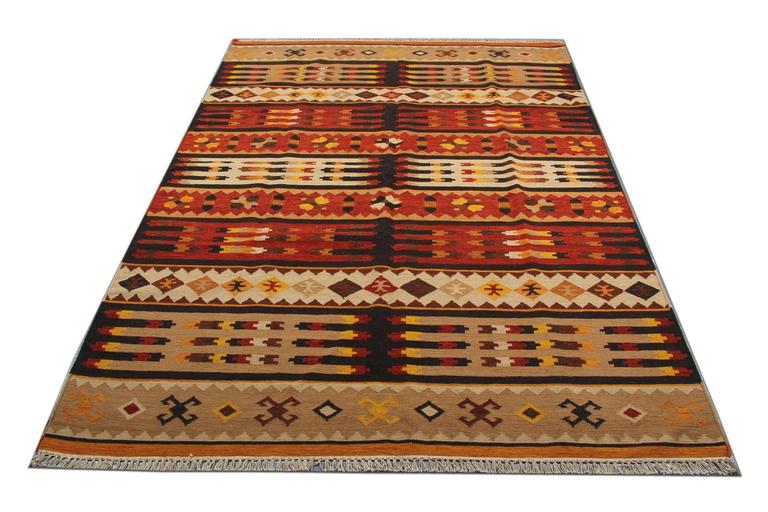 This fine wool area rug has been woven by hand and features a fantastic geometric design. Woven in accents of brown beige and rust. Symmetrically woven with sophistication, this piece is sure to uplift any room it is introduced to. Style this