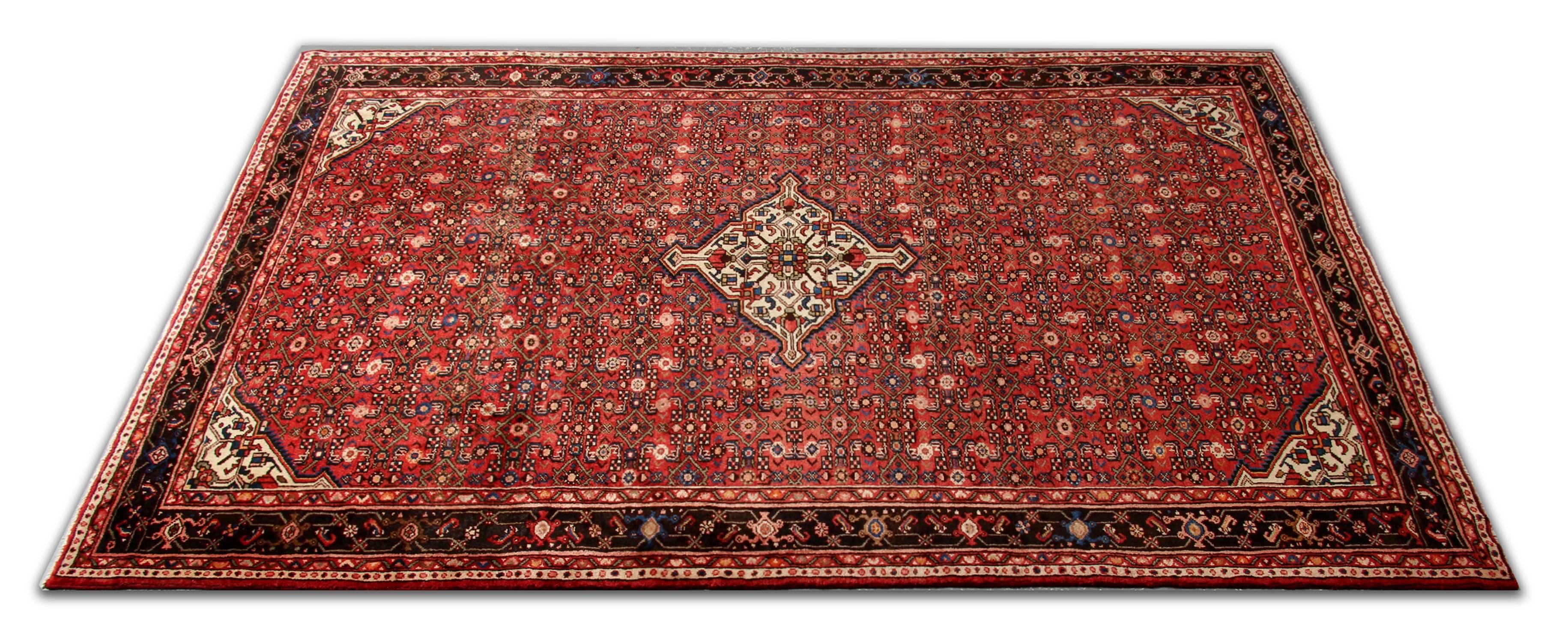 Ce fantastique tapis en laine présente un motif central traditionnel all-over, tissé dans des tons rouges et bruns, avec un beau médaillon et des coins décoratifs tissés sur un fond ivoire contrastant. Ce motif luxueux est ensuite entouré d'une