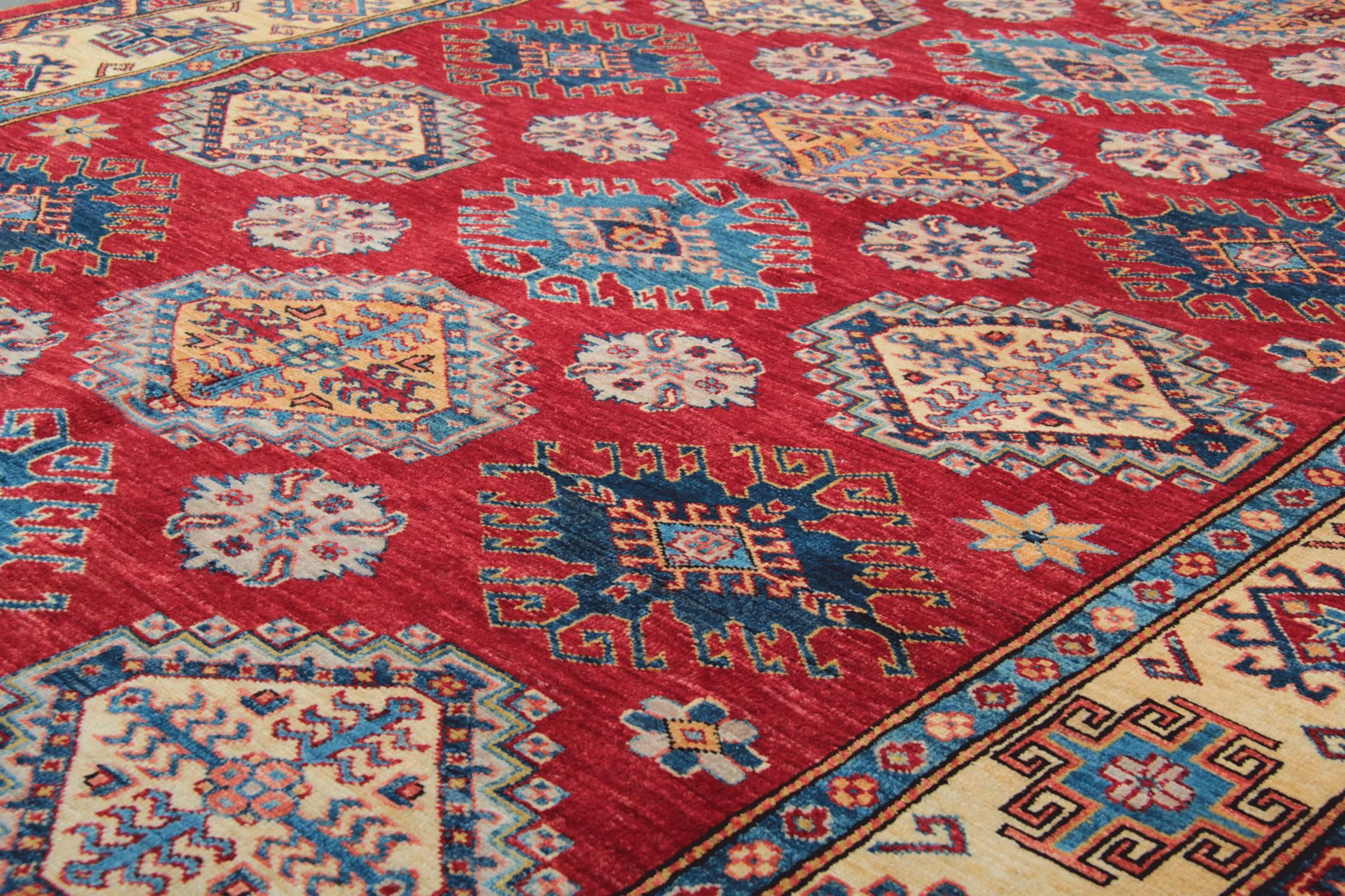 This is an example of a handwoven rug, which is featuring designs from the Kazak region. Northern Persia is famous with its traditional rugs design. The Afghan weavers used top quality wool and cotton for the production of this red rug. These tribal