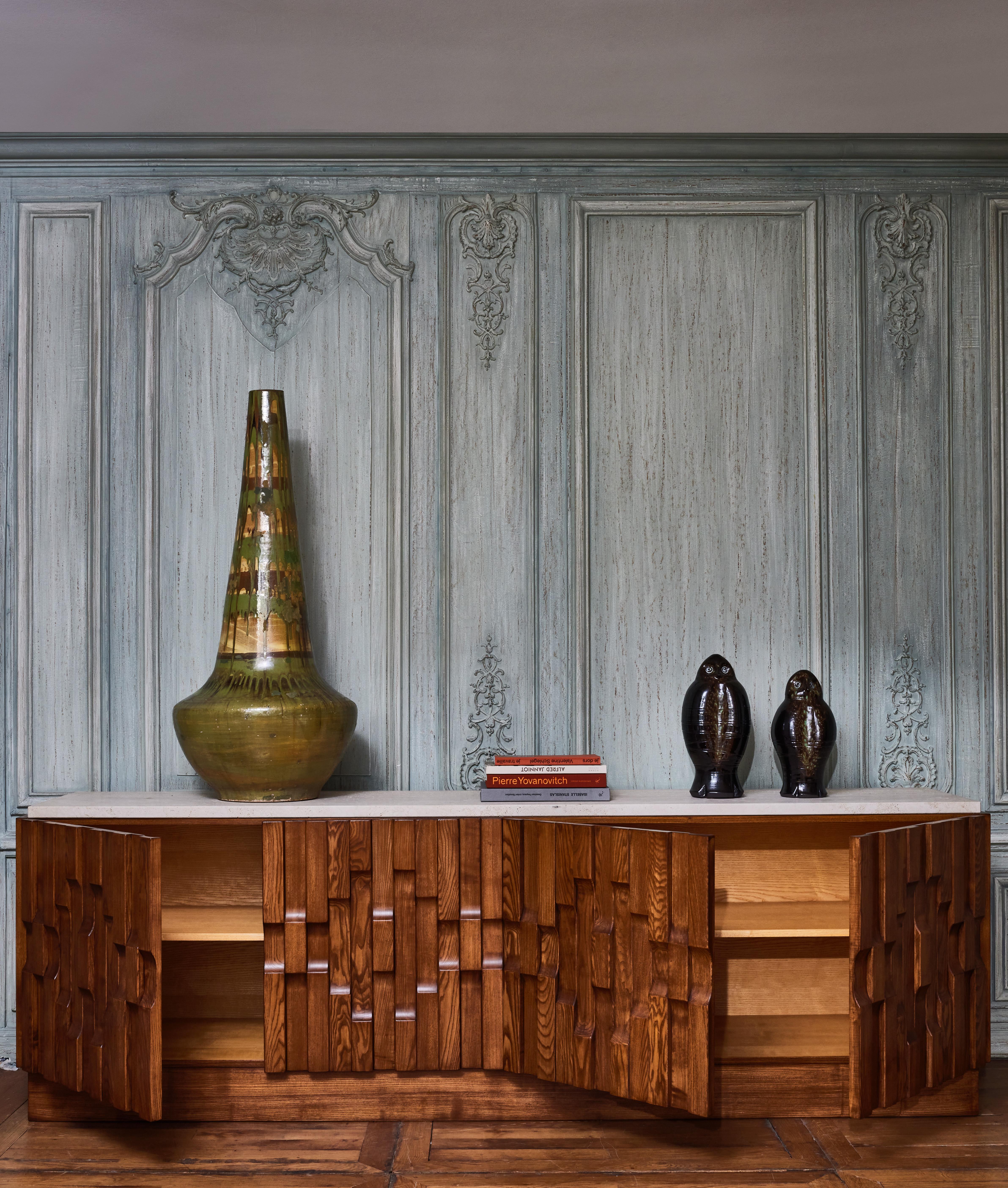 4 doors sideboard in sculpted wood and travertine stone top.
Creation by Studio Glustin.