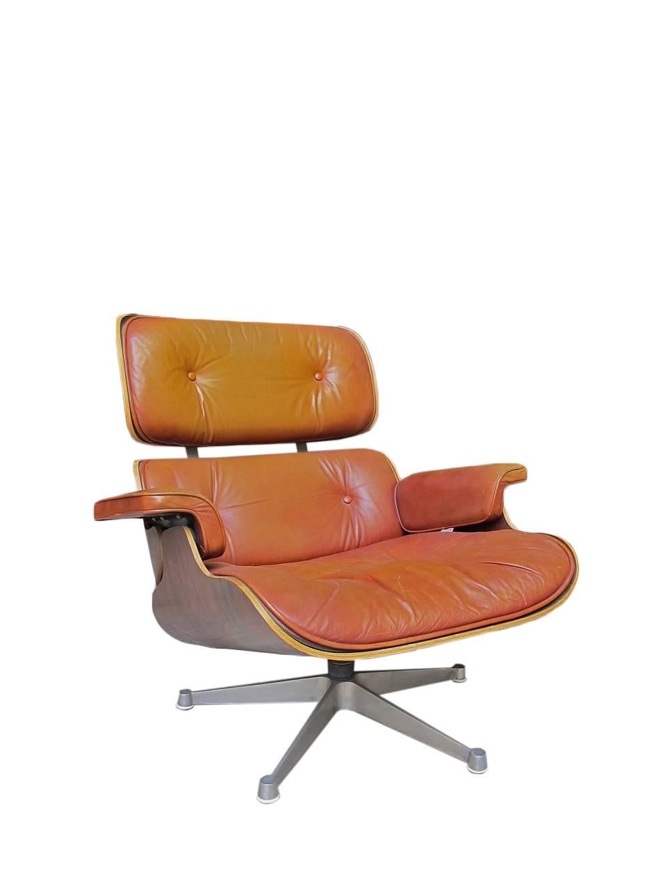 Lounge Chair and ottoman designed by Charles and Ray Eames and Herman Miller bent plywood, finished in rosewood, original leather upholstery color, cognac.  Steel legs with feet finished in pill.   
Production USA 1950.
Ottoman measures: 65 x 57 x
