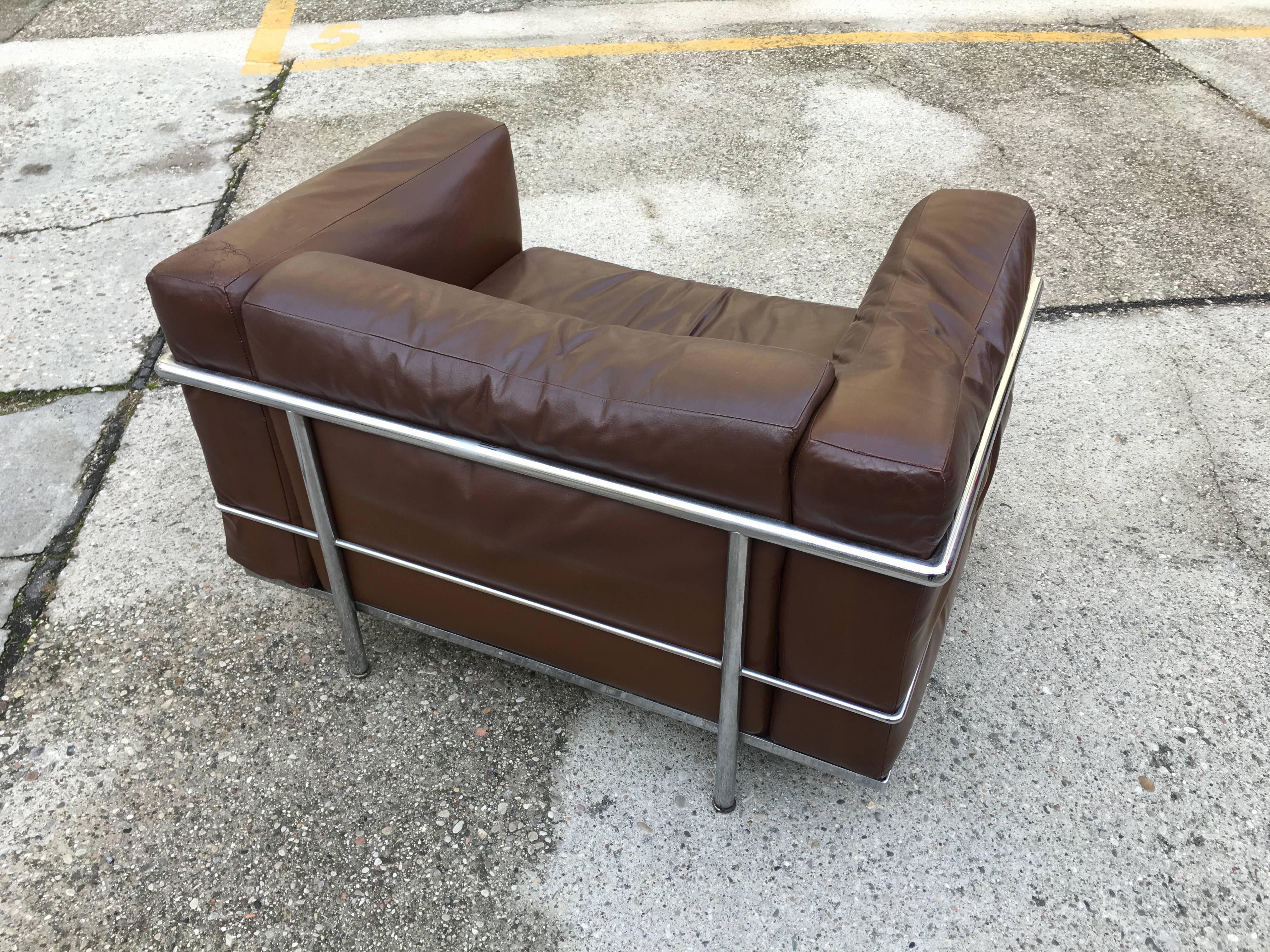 Designed by Le Corbusier in 1928, this modern club chair is composed of a chrome frame and four original brown leather cushions. Manufactured by Cassina. Numbered one of the first productions # 147, signed, this ticketing of Cassina, the skin is in