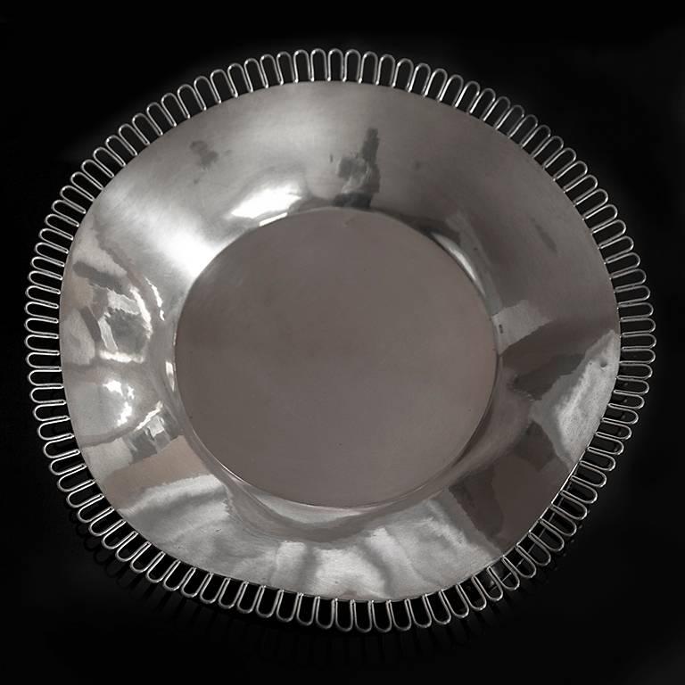 A silver centerpiece Sant'Elia Dish by Arrigo Finzi, Italy circa 1933, of circular ruffled form with looped border, the underside stamped with designer's mark, date mark and standard mark. 

     