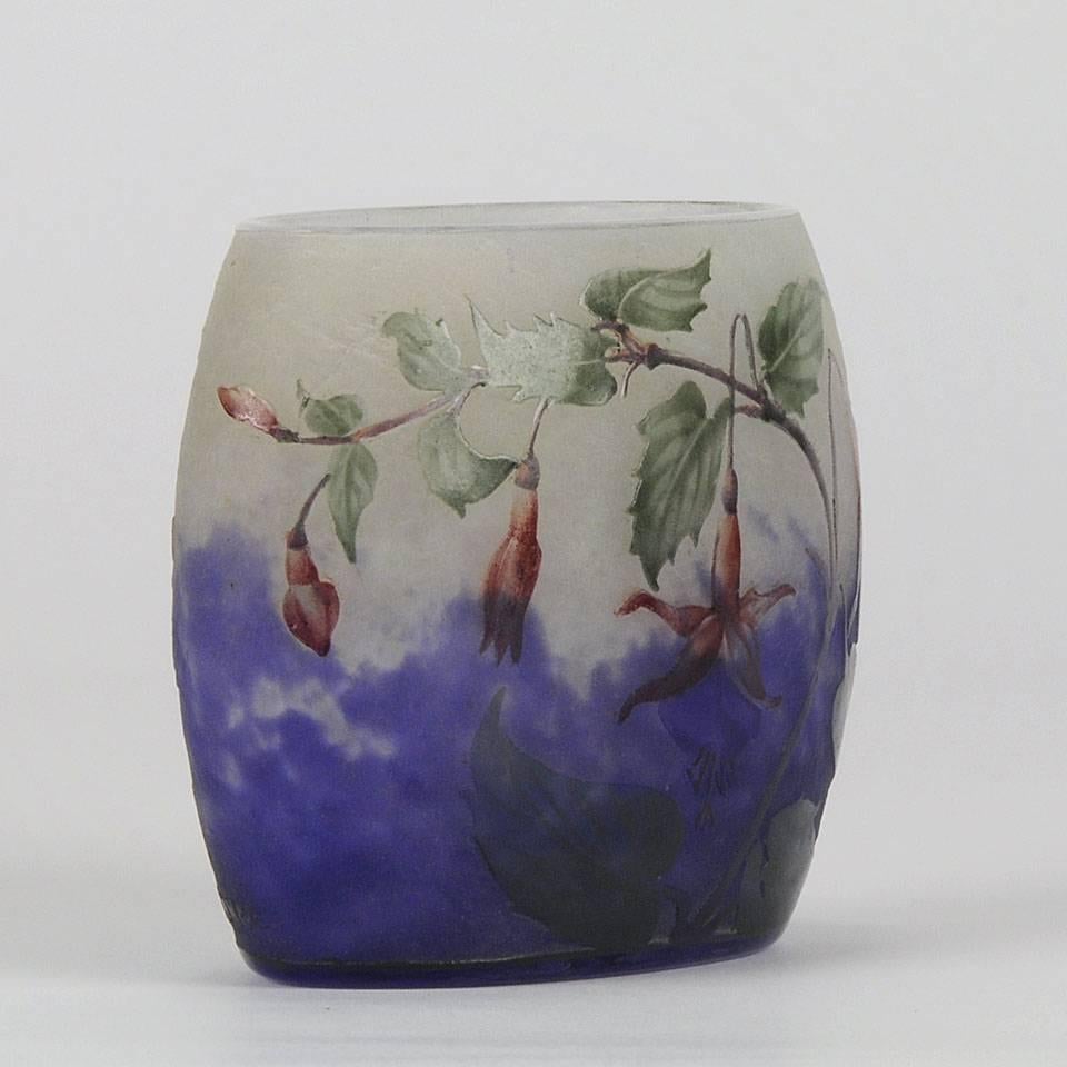 An excellent cameo glass pillow shaped vase etched and enamelled with a hanging fuschia landscape against a purple field fading into deep white, with vibrant colors and fine detail. Signed in cameo Daum Nancy, France and with Cross of Lorraine and