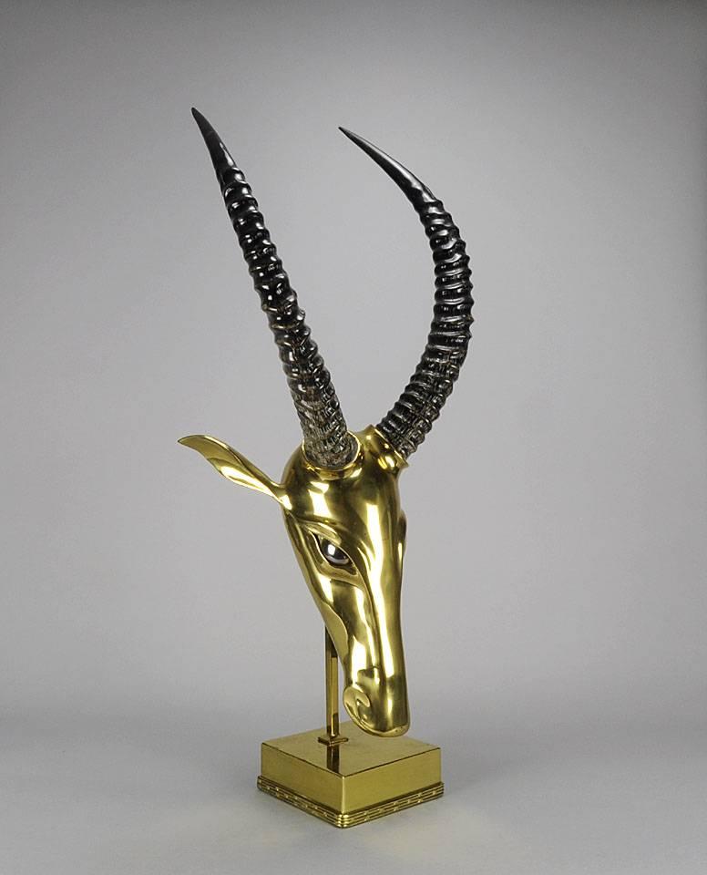 A visually striking one-of-a-kind polished brass Antelope’s head modelled in a Modernist style with captivating silvered eyes. Finished with real bluebuck Antelope horns, raised on fitted support and matched square shaped base, signed J Brasseur.
 