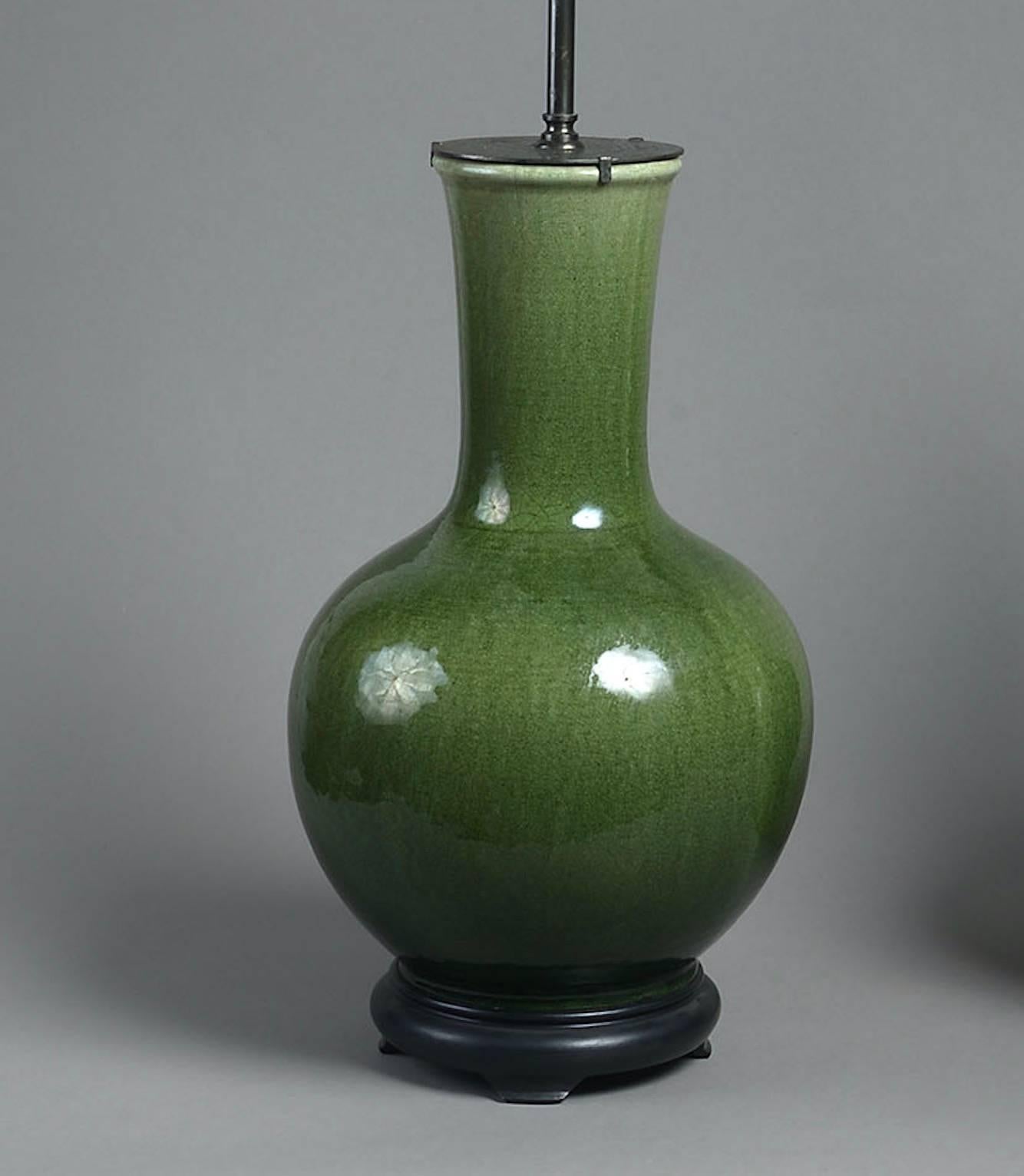 A very fine pair of 19th century moss-green glazed Chinese vases with craquellure surface, now mounted as lamps. 

Height of vase: 17 3/4 in (45 cm) including base, excluding electrical fitments and lampshades 

This lamp can be wired for use