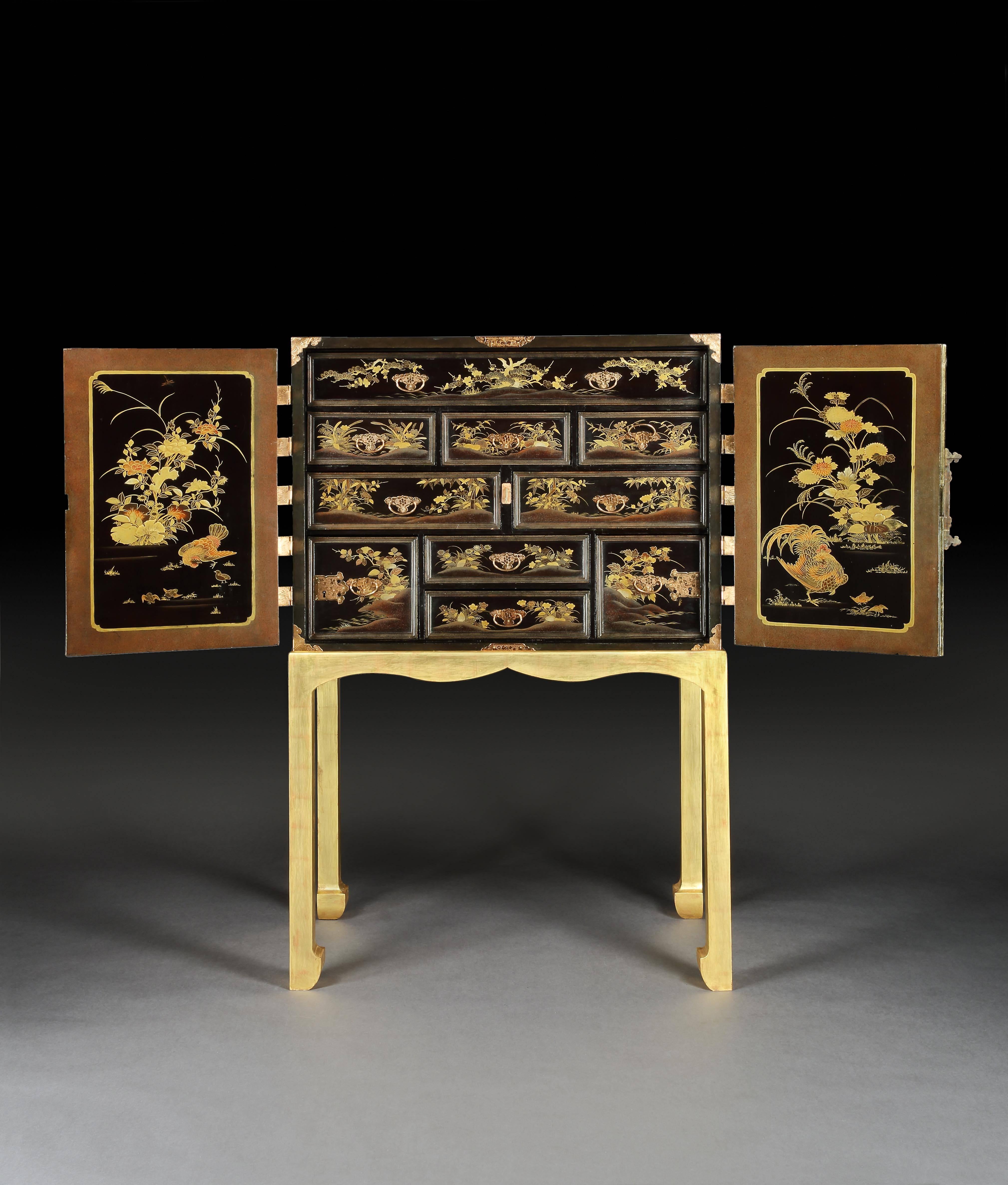 An exceptional Japanese Edo period black and gilt lacquer cabinet decorated throughout, including the top, with mountain landscape scenes, with a pair of doors with copper engraved mounts, hinges and lock-plates opening to reveal ten drawers of