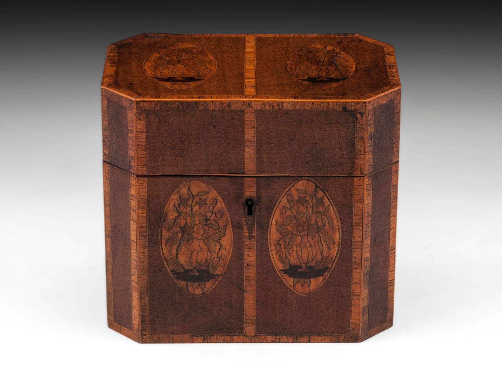 Antique tea chest veneered in harewood with decorative oval medallions of tea plants to the front and top, framing each panel of the chest is a Tulipwood crossbanding with box wood either side. 

The tea chest interior features two engraved