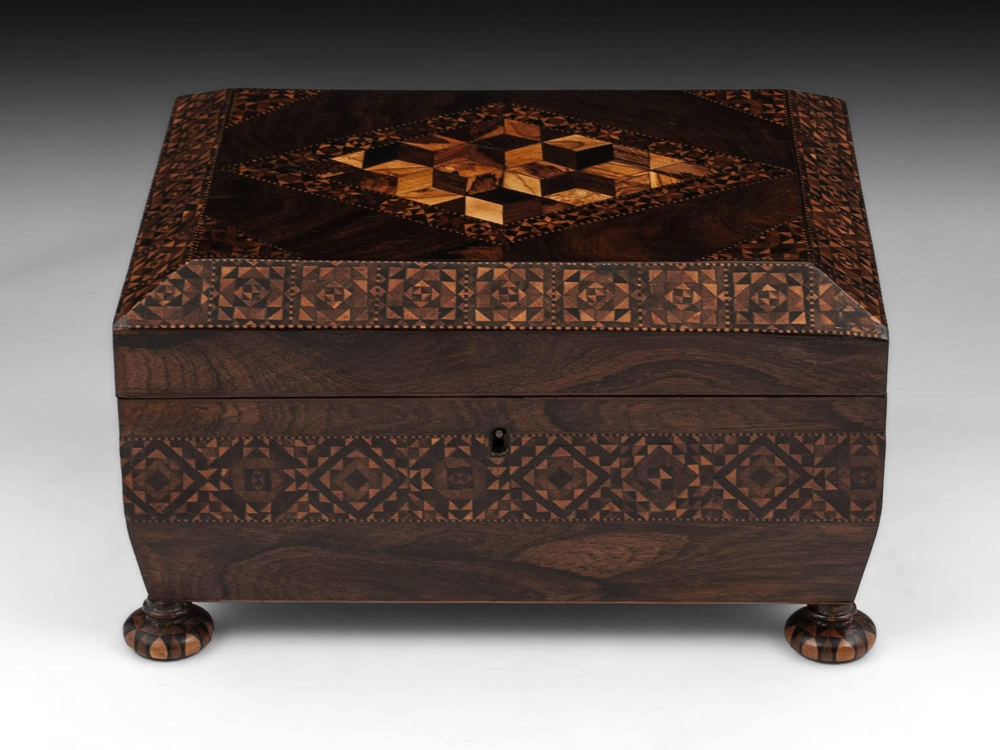 Antique Tunbridge Ware Sewing Box veneered in mahogany with perspective cube diamond design on the top and stands on four turned stick ware wooden feet. 

The interior features a removable sewing tray which has a large storage space underneath. The