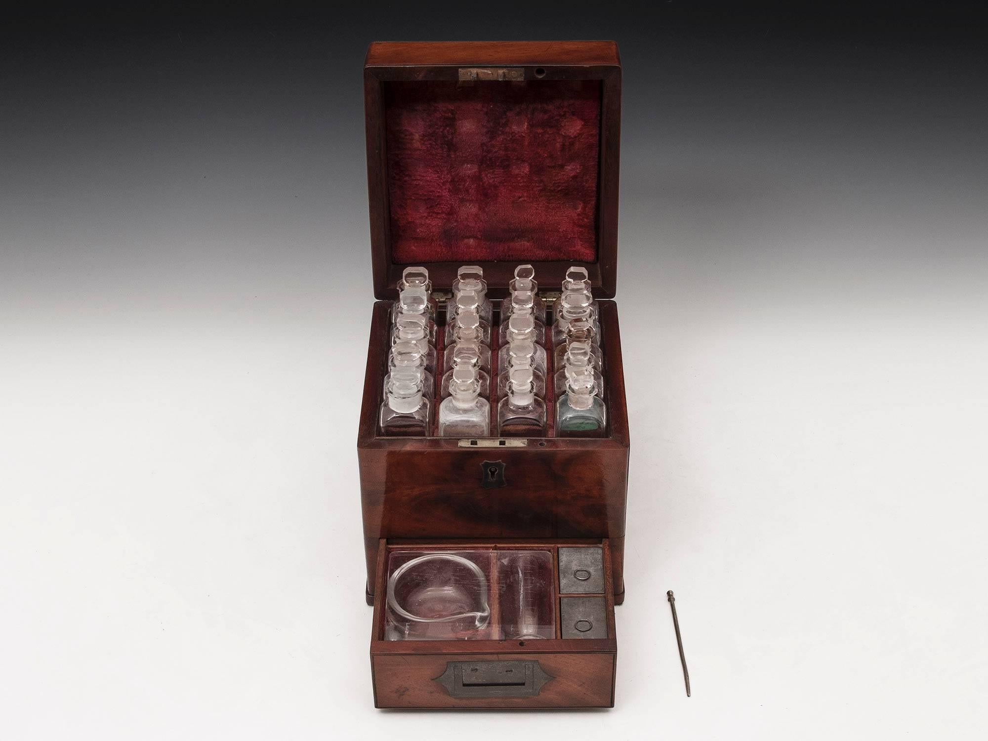 Apothecary box made of solid mahogany with flush fitting campaign handles, contains all of its original contents and the wooden case has superb patination and colour. 

The interior is lined in red velvet and contains twenty glass bottles complete