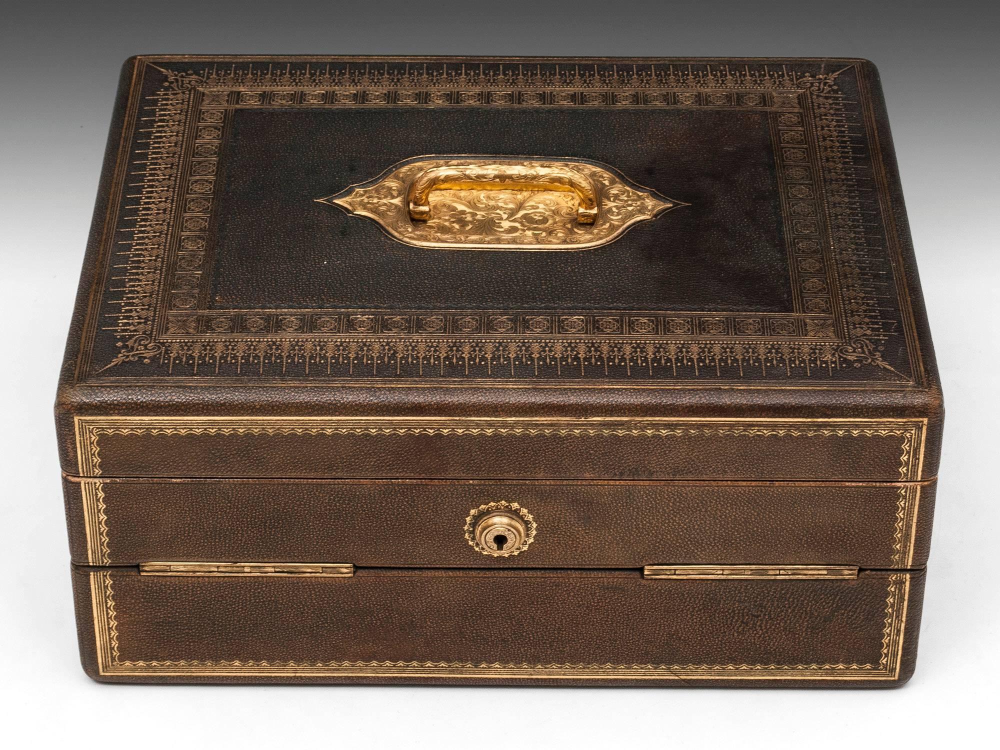 Leather bound writing box by W & J Milne, Edinburgh. 
The gorgeous mottled leather exterior is decorated with fine gold tooling and features ornate gilt brass carry handle and escutcheon. 

The interior features a vibrant blue velvet and leather