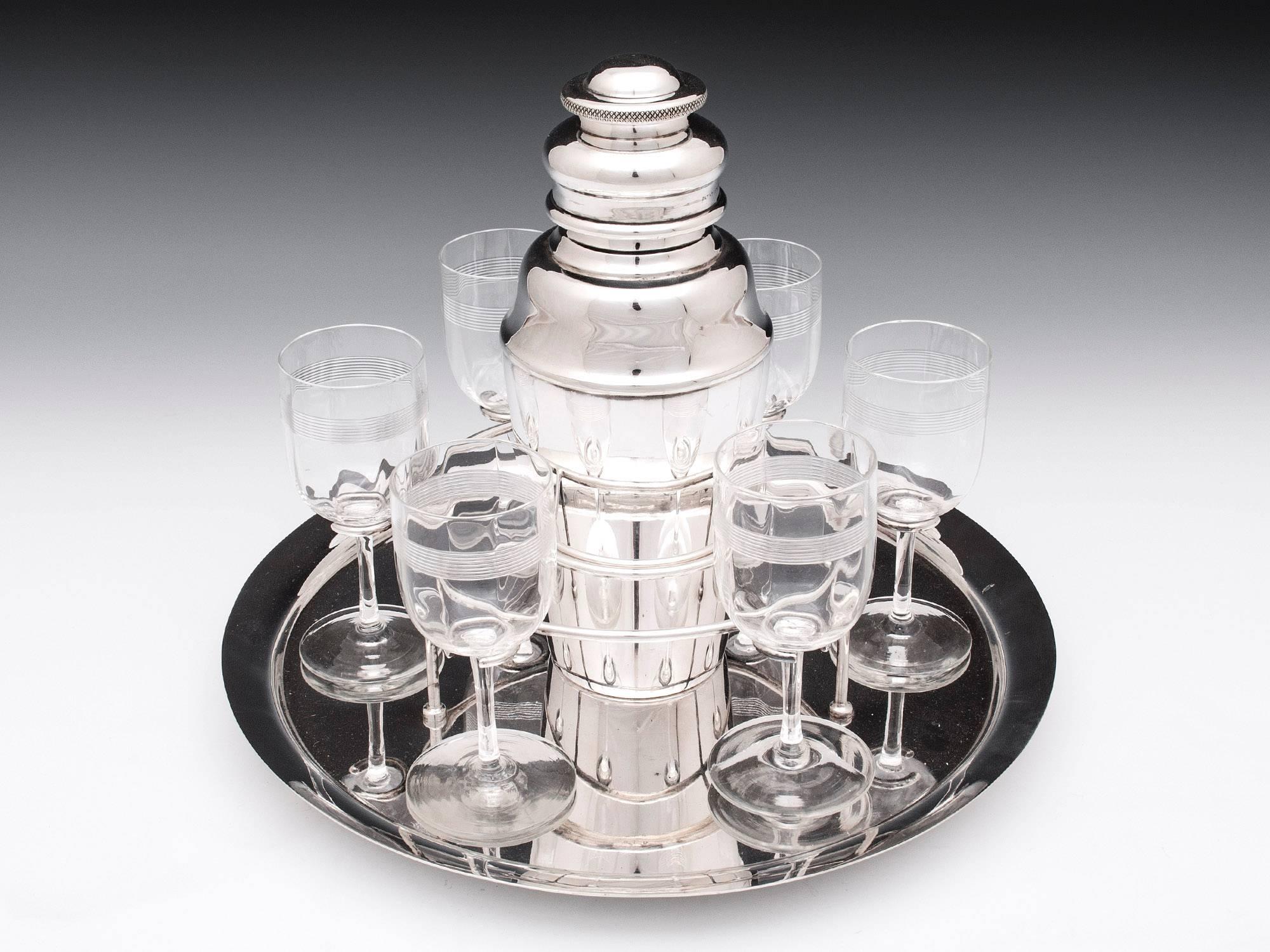 Art Deco silver plated cocktail set by Hukin & Heath complete with a silver plated tray, marked "935", and six glasses. 

Cocktail shaker dimensions: 
Height 8' 
diameter 3.25' 

Glass dimensions: 
Height 4.5' 
diameter 2'
