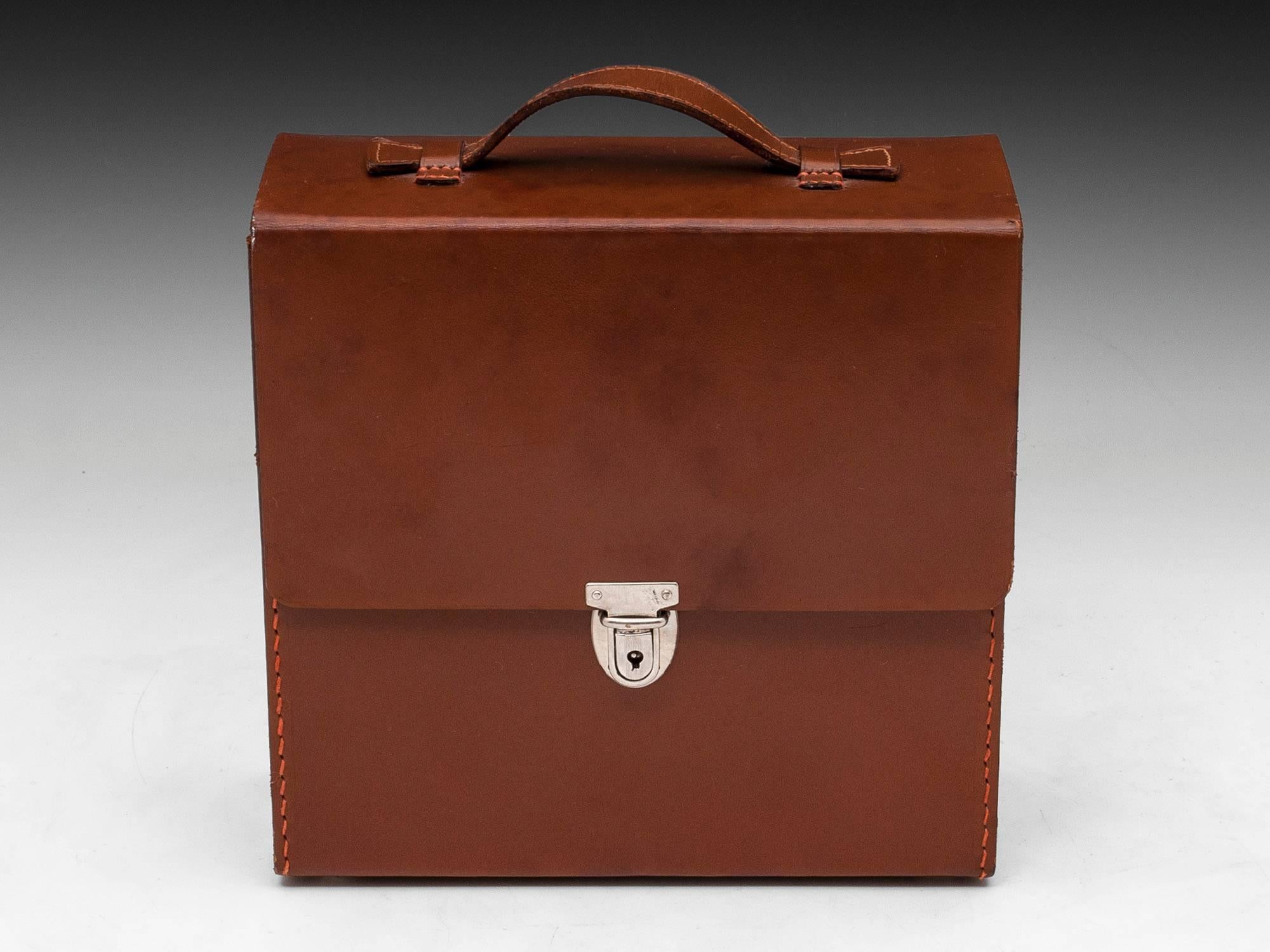 Leather Travelling Cocktail case comprising of: Shaker with gold plated lining, two glass spirit containers with shot beakers, combination bottle opener & cork screw. 

The Cocktail shaker base is stamped 