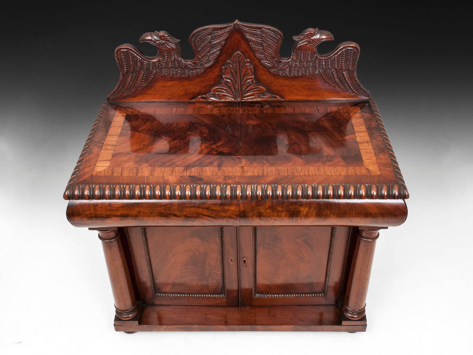 This stunning mahogany piece has fabulous colour and patination throughout and features a beautiful detailed carved back splat of a pair of eagles surrounding a carved leaf. The top is veneered in flame mahogany and crossbanded in rosewood. To the