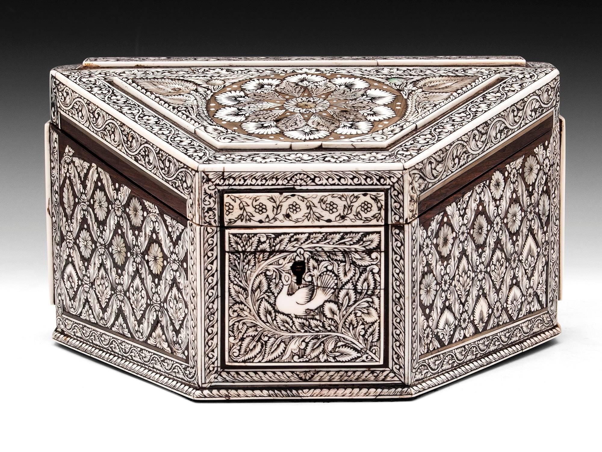Anglo-Indian ivory Vizagapatam stationery box made of padouk and buffalo horn. Decorated with engraved and lac filled flowing floral patterns with a large symmetrical flower design on the top highlighted by mother-of-pearl inlays. The sides, front