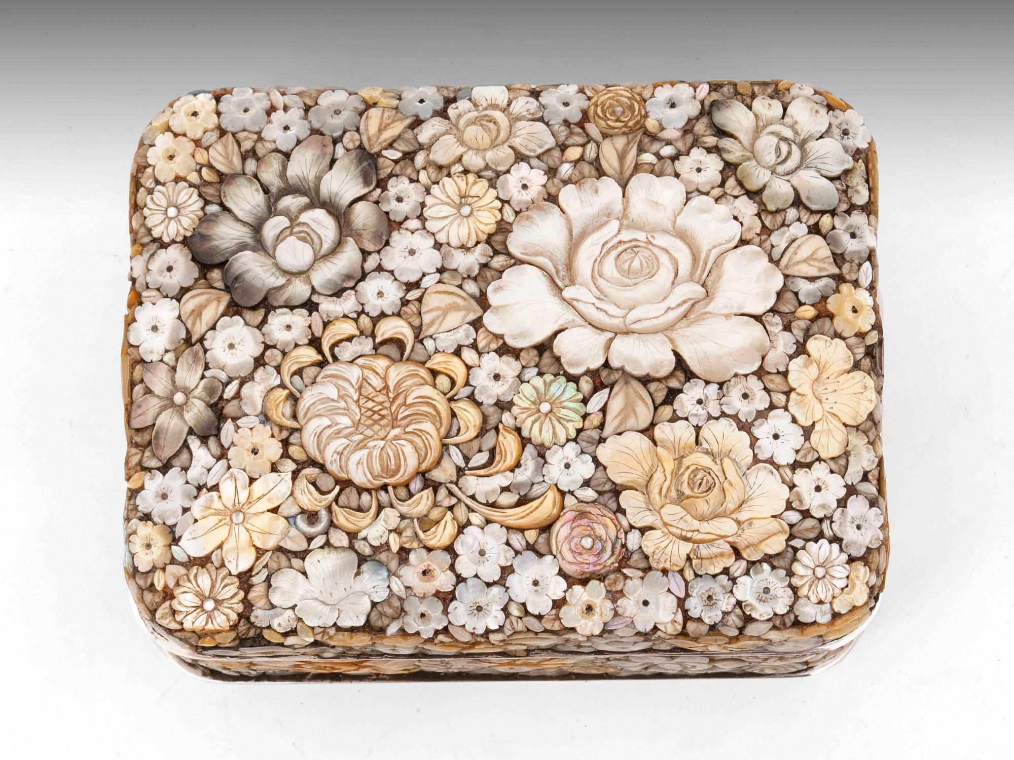 A rare and superb box encrusted with 100 of detailed engraved flowers and leaves of mother of pearl, abalone and bone. The base and lid have a silver rim, which helps to protect the delicate mother of pearl.
The lid lifts to reveal a beautiful