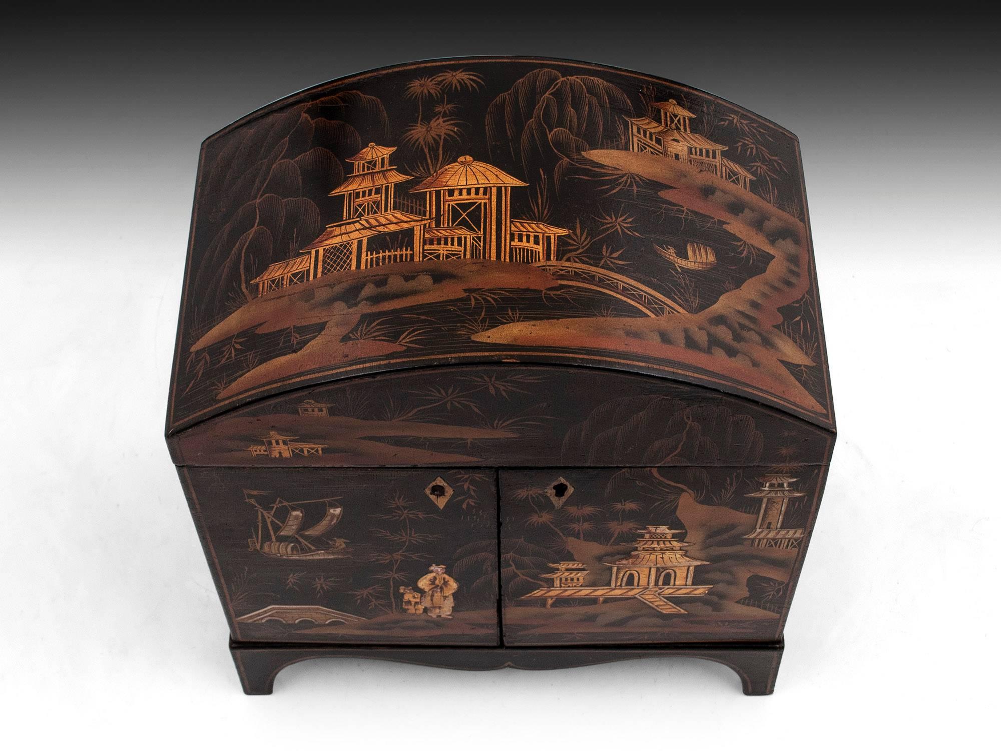 An early 19th century japanned sewing cabinet, with chinoiserie decoration on each side in beautiful warm tones against a contrasting black.
The lid lifts to reveal several compartments for thread spools, pincushion, thimbles and further storage.