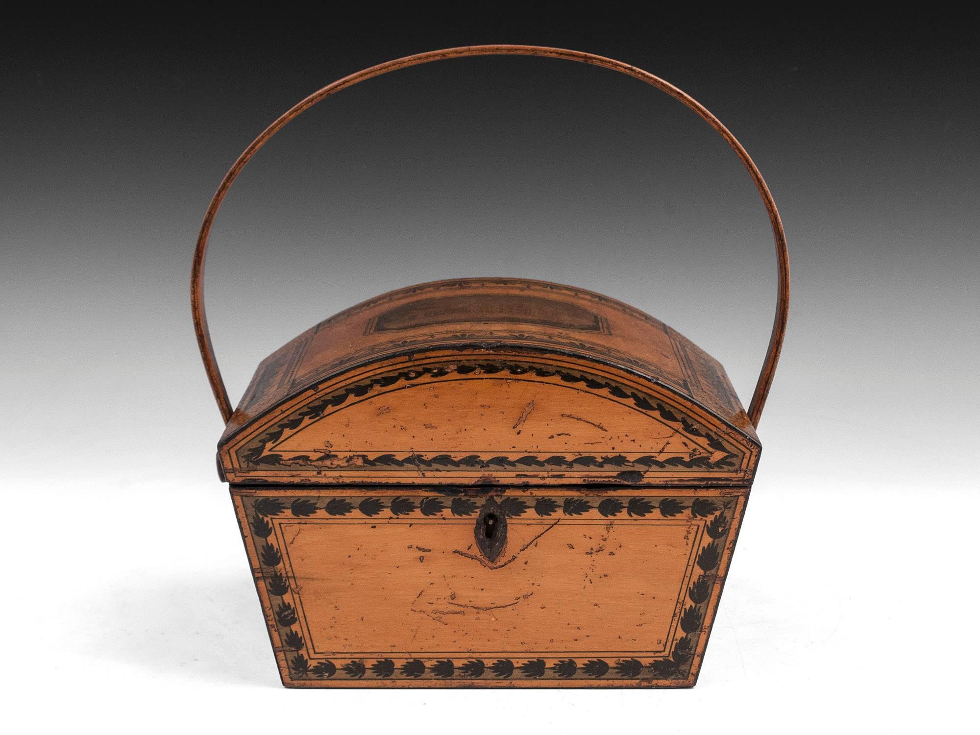 Early Tunbridge ware sewing basket, with green and black patterned borders, continuing along the handle. 

The interior is lined in blue paper and features several compartments for thread reels, thimbles, needle books and other sewing equipment