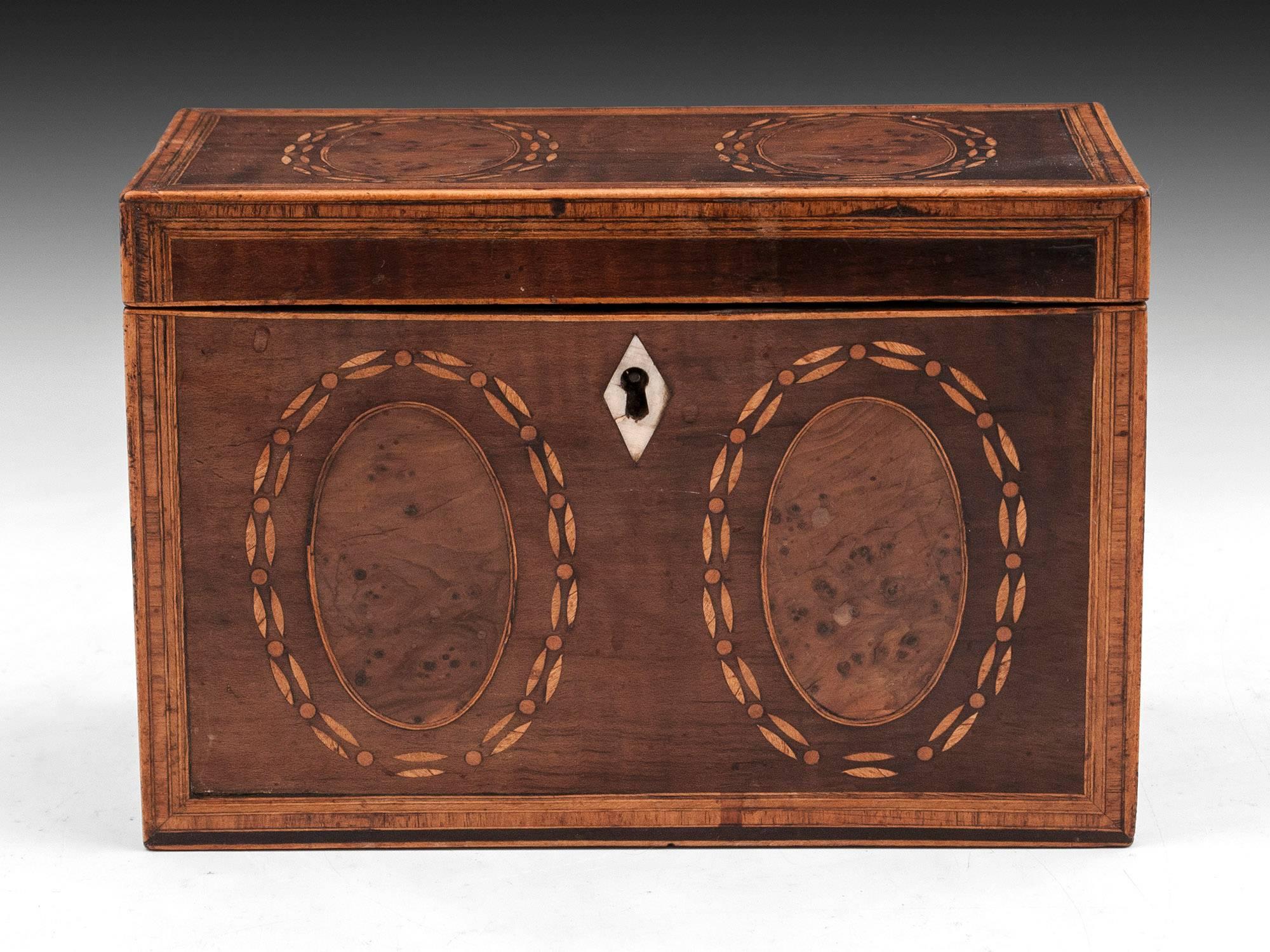 Antique tea caddy veneered in harewood with inlaid burr yew ovals and decorative inlays surrounding them, has bone escutcheon.

The interior of this Georgian tea caddy features two bone handled lidded compartments, comes with a key and working