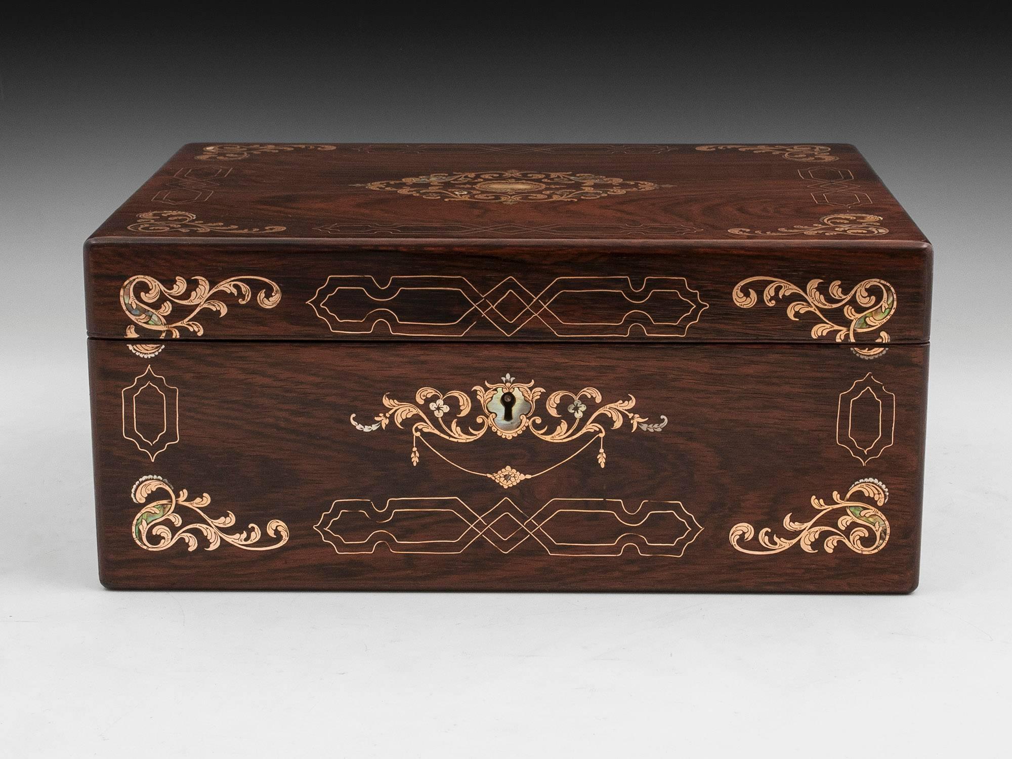 Rosewood sewing box with exquisite inlaid designs of brass, pewter and Mother of Pearl. 

The interior is lined in blue silk and silver paper. Featuring a silk backed ruched lid and a removable tray which contains several compartments including