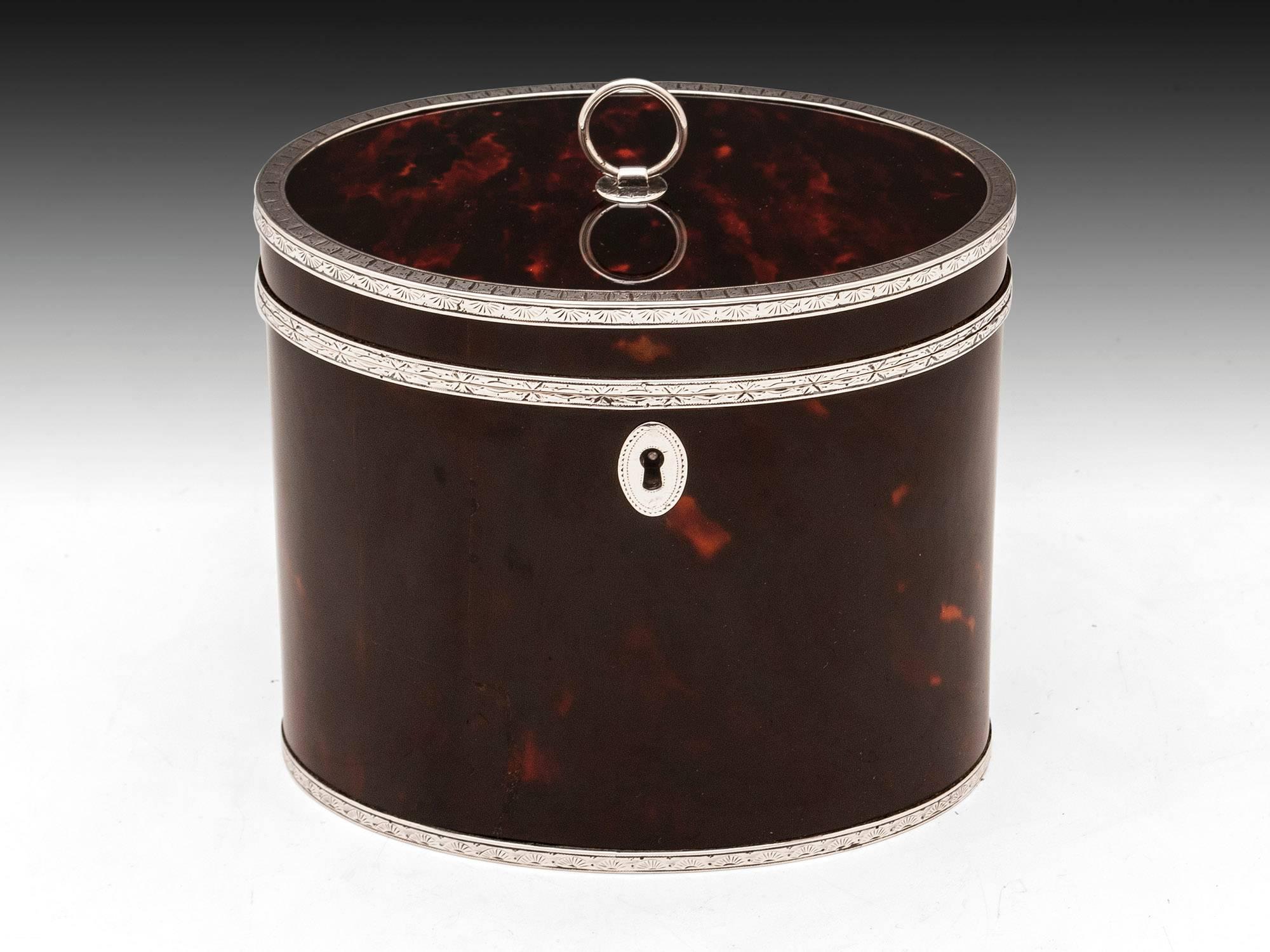 Very rare, striking red tortoiseshell and silver oval tea caddy with beautifully engraved solid silver edging, escutcheon and ring pull handle. 
The silver edge on the opening of the caddy has the hinge expertly incorporated into its design. The