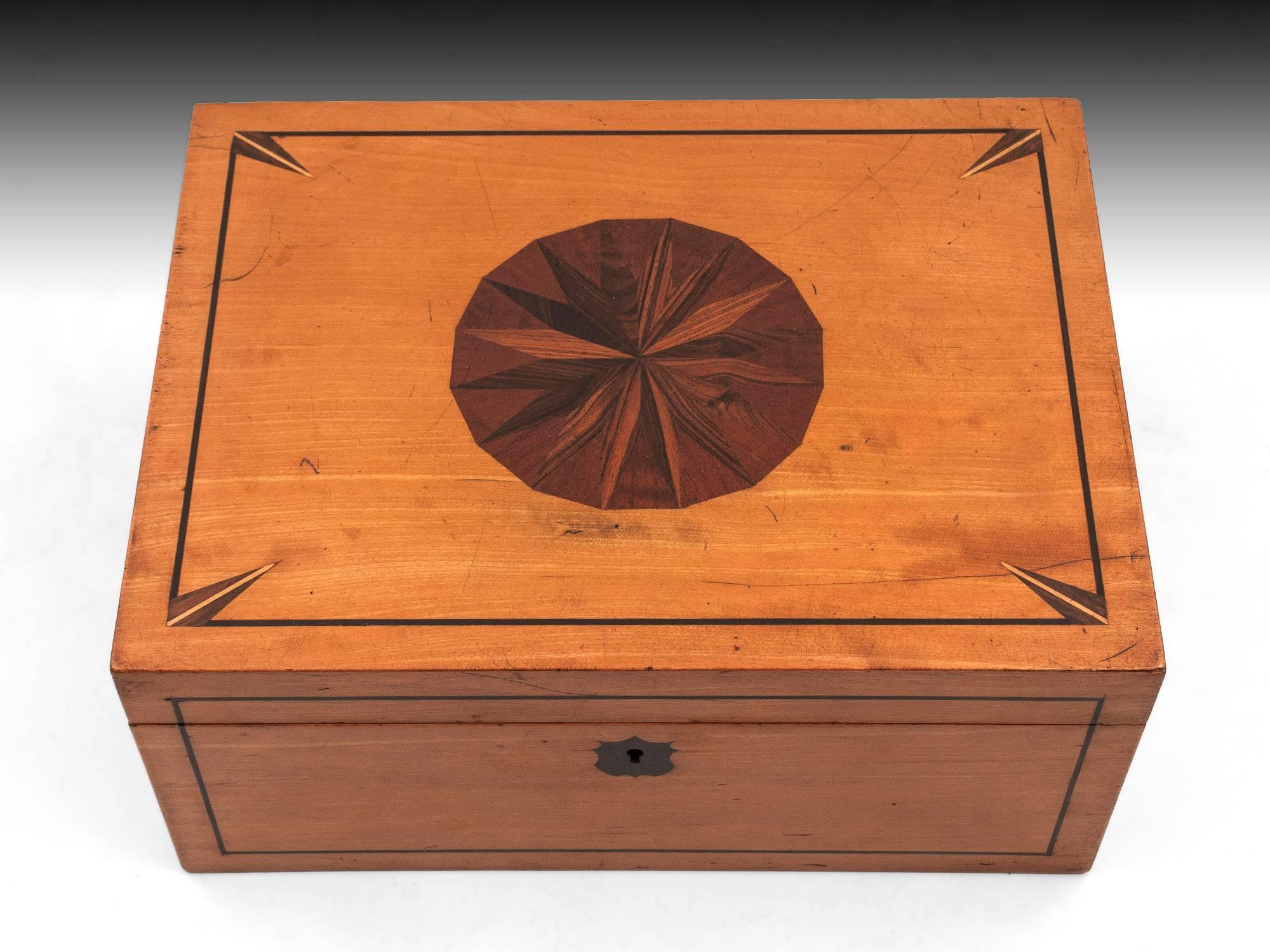 Satinwood box with a beautiful star motif made up of kingwood, mahogany and rosewood to the top and a coromandel shield-shaped escutcheon on the front. This box although empty of its contents we believe this was for holding various games.