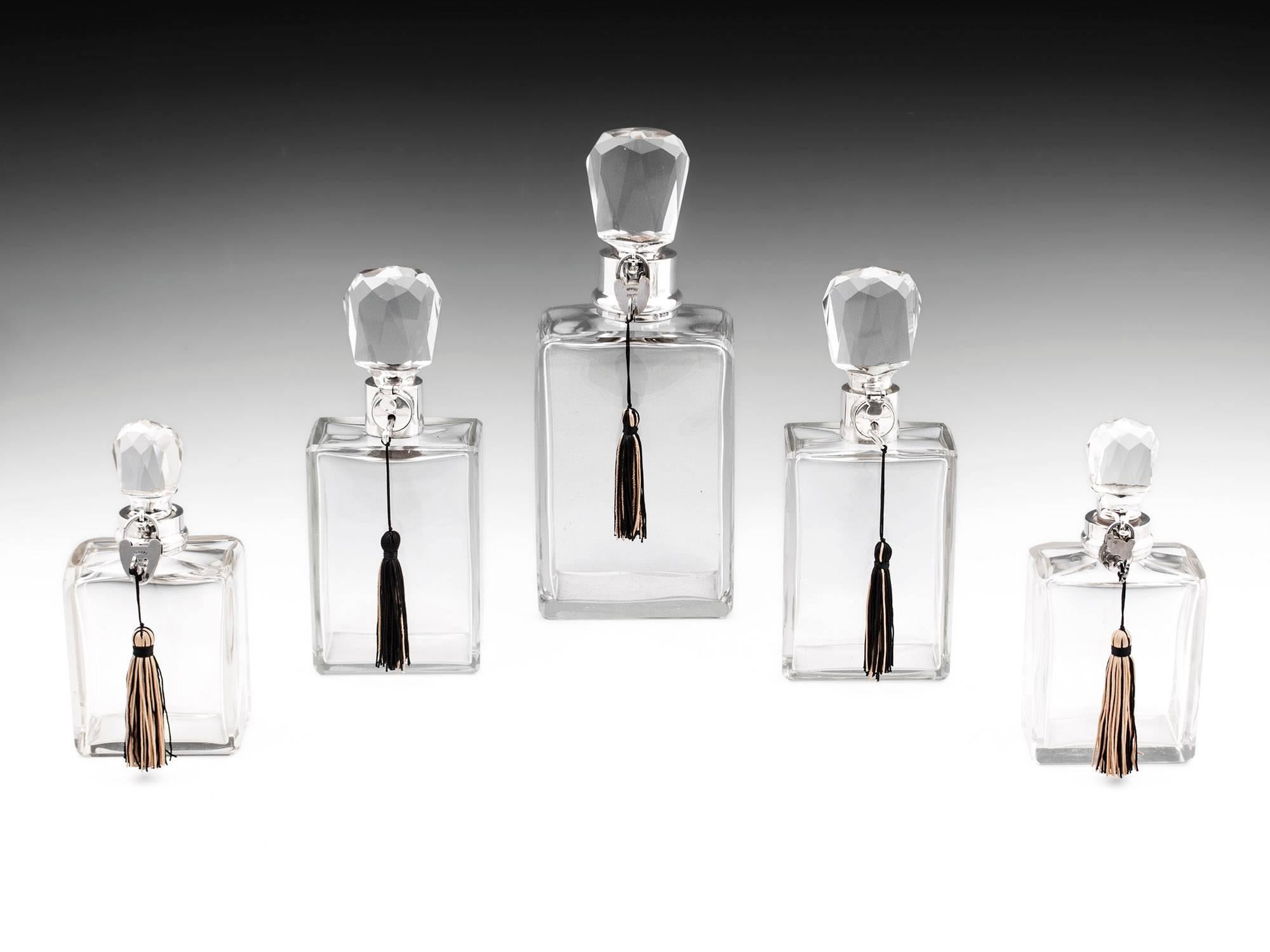 Art Deco silver collared lockable decanters in graduating sizes by silversmith Hukin & Heath. Extremely rare and simply stylish Art Deco decanters. Each one bearing the hallmarks for Hukin & Heath.

The large decanter which is silver