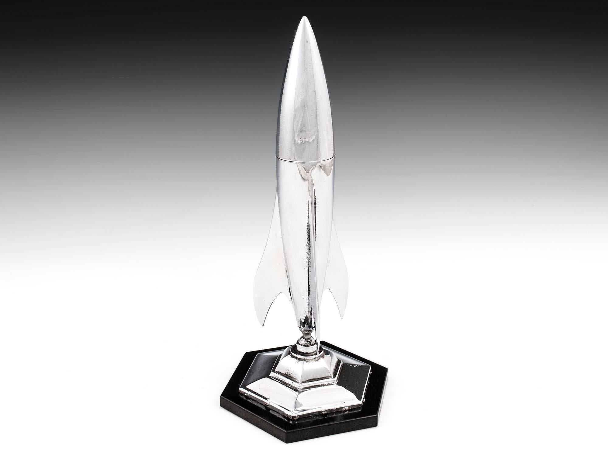 Art Deco chrome-plated table lighter in the form of a rocket. 

The rocket is attached via a ball joint, allowing it to swivel and be posed at an angle from the base. 

The top half of the rocket can be removed to reveal the table lighter which