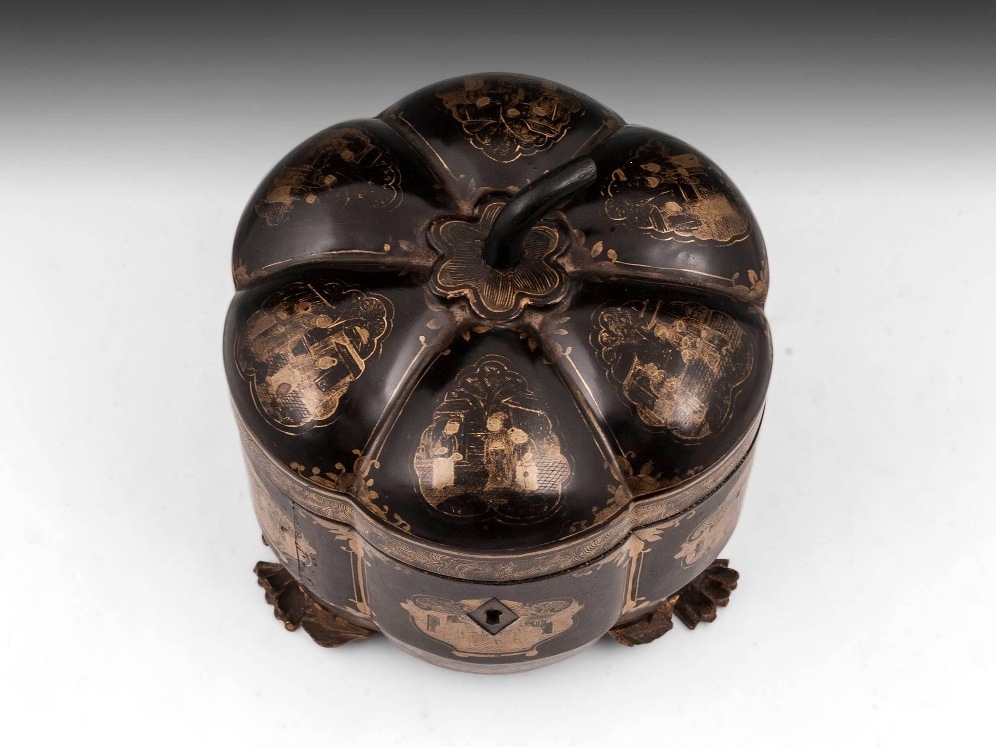 Chinese lacquer melon tea chest decorated with chinoiserie scenes in gold, standing on three carved dragon’s feet.

The interior of the chinese tea chest houses a engraved paktong tea caddy with bone handled lid.

This Chinese melon tea chest