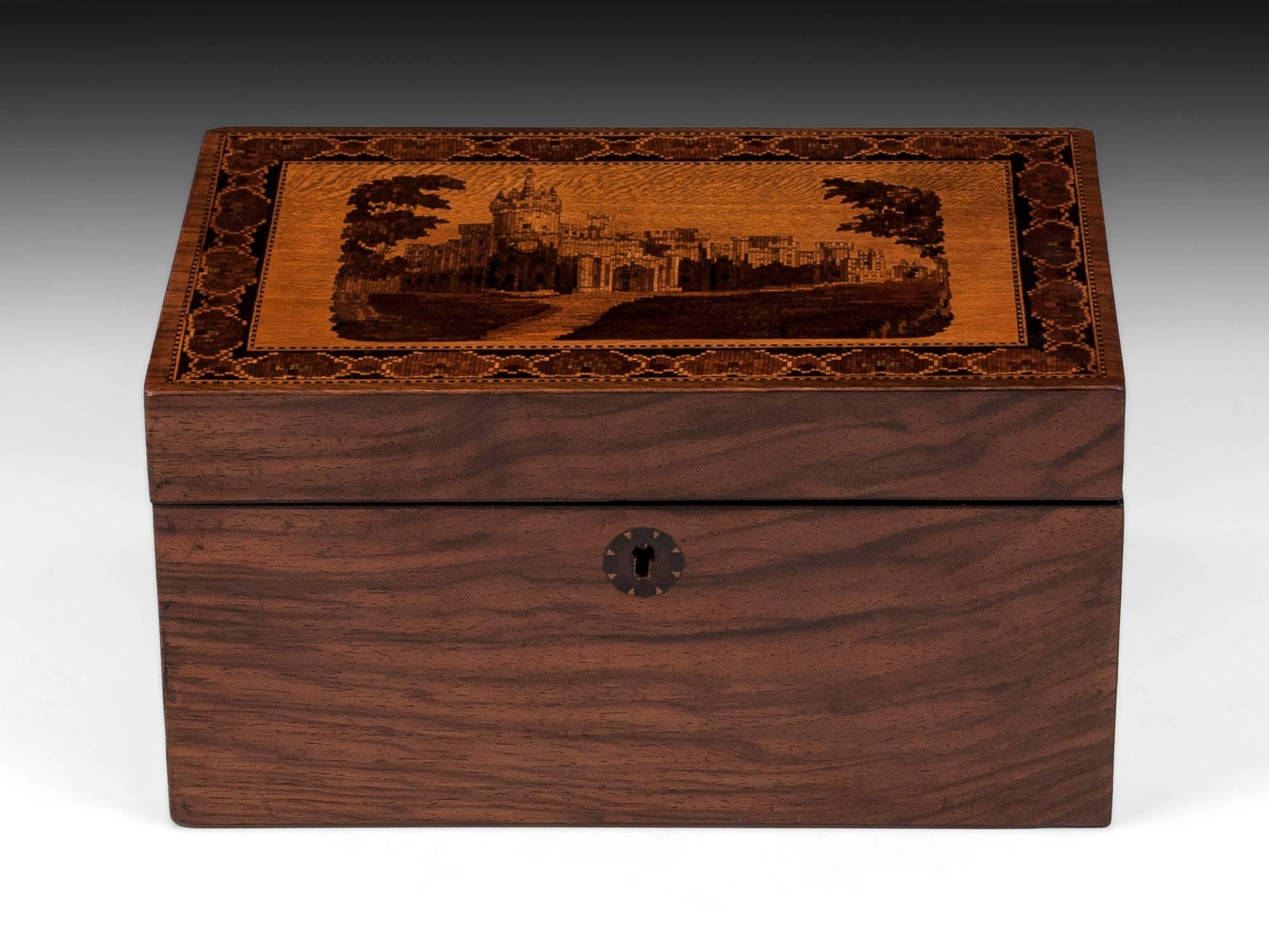 Tunbridge ware tea caddy with a view of Eridge castle on the top, veneered in Walnut. 

The interior of this Tunbridge ware tea caddy features two lidded compartments with traces of their original lining. On the back edge of the lid is a label which