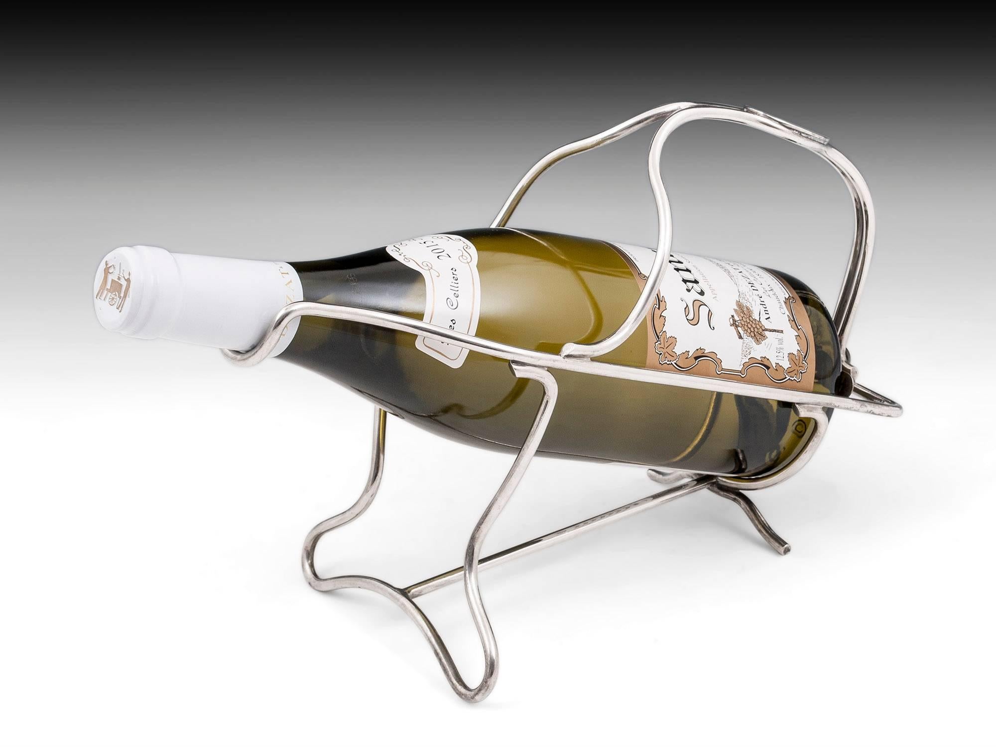 Silver plated wine pourer by French designer Christofle. The wine bottle is secured tightly within the frame by a cross spring at the back of the cradle, this makes the pouring simple, easy and with out the worry of the wine moving within in the
