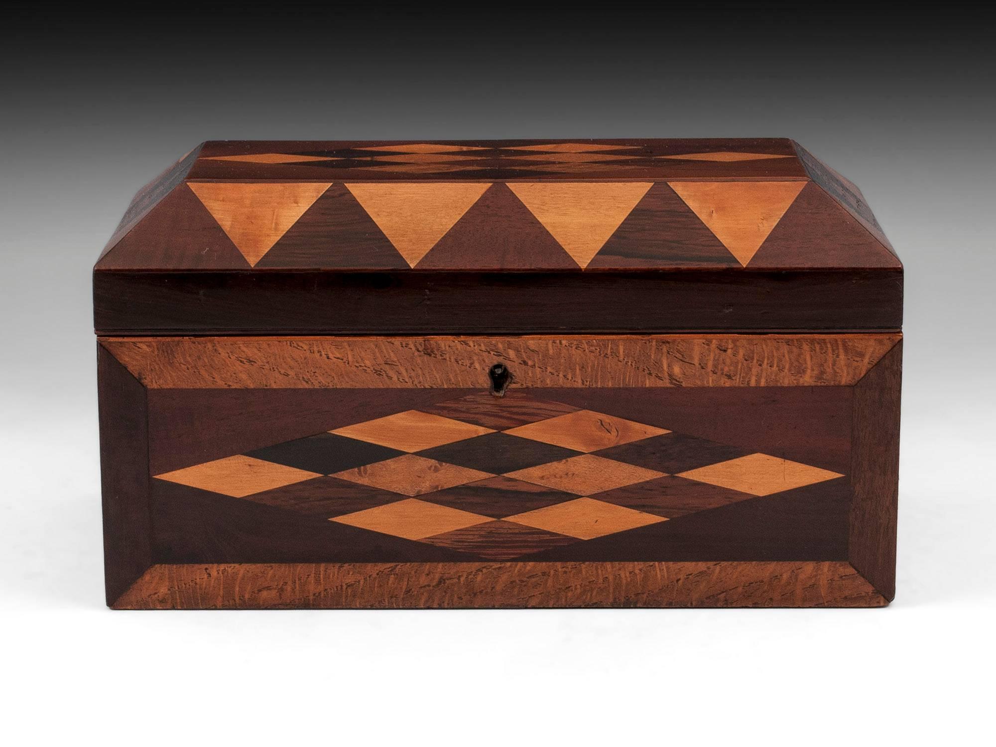 Antique box with diamond shaped design to the top and front with triangle shapes on the canted top. The veneered used to make the diamond patterns are; oak, maple, mahogany, palm, satinwood, Coromandel and cedar.

The interior of this decorative