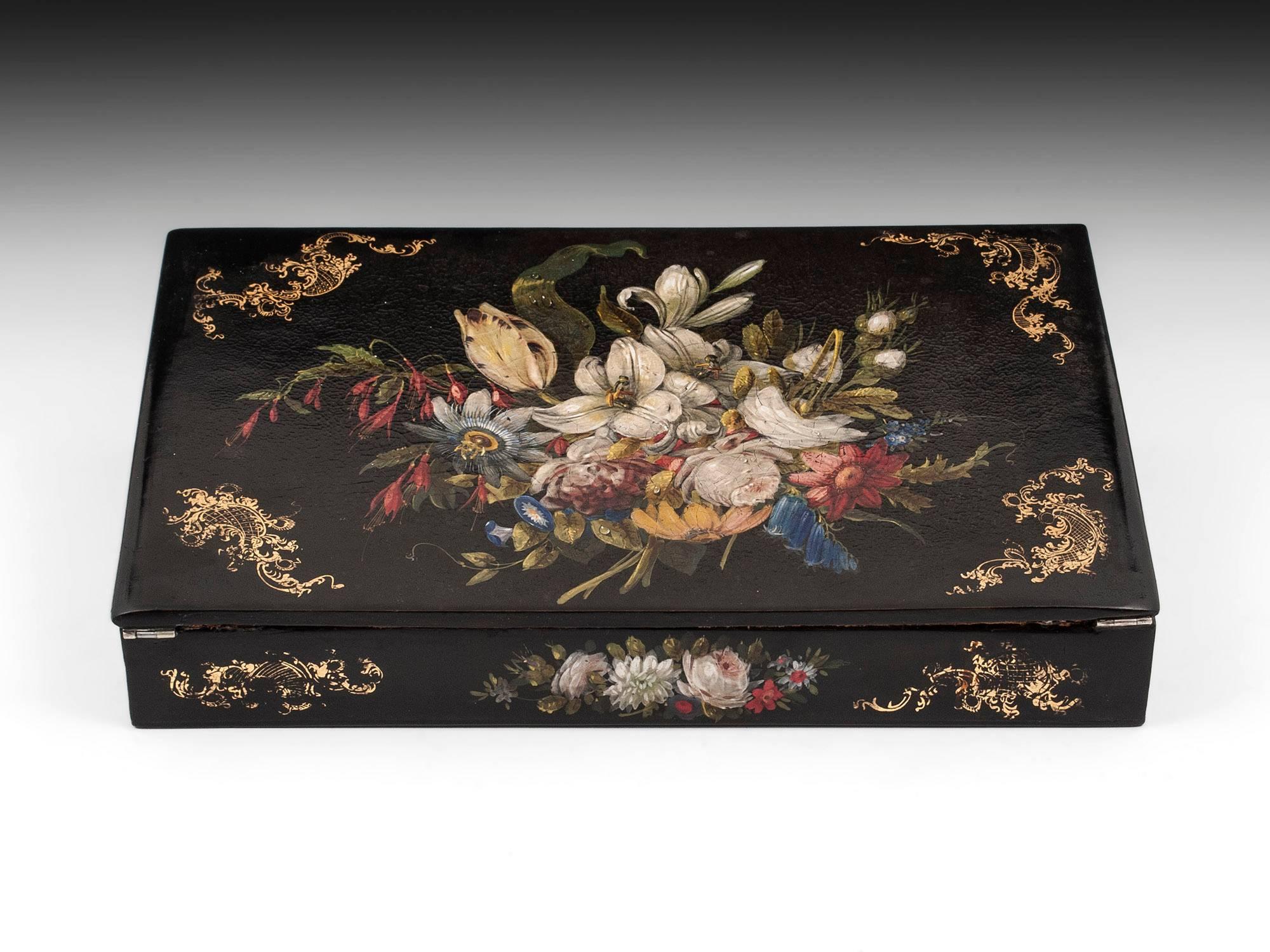 Beautiful papier mâché writing slope with stunning floral paintings on the top and sides. 

The interior of the writing slope features its original red velvet writing surface with gold tooling. The top half can be lifted to reveal a large storage