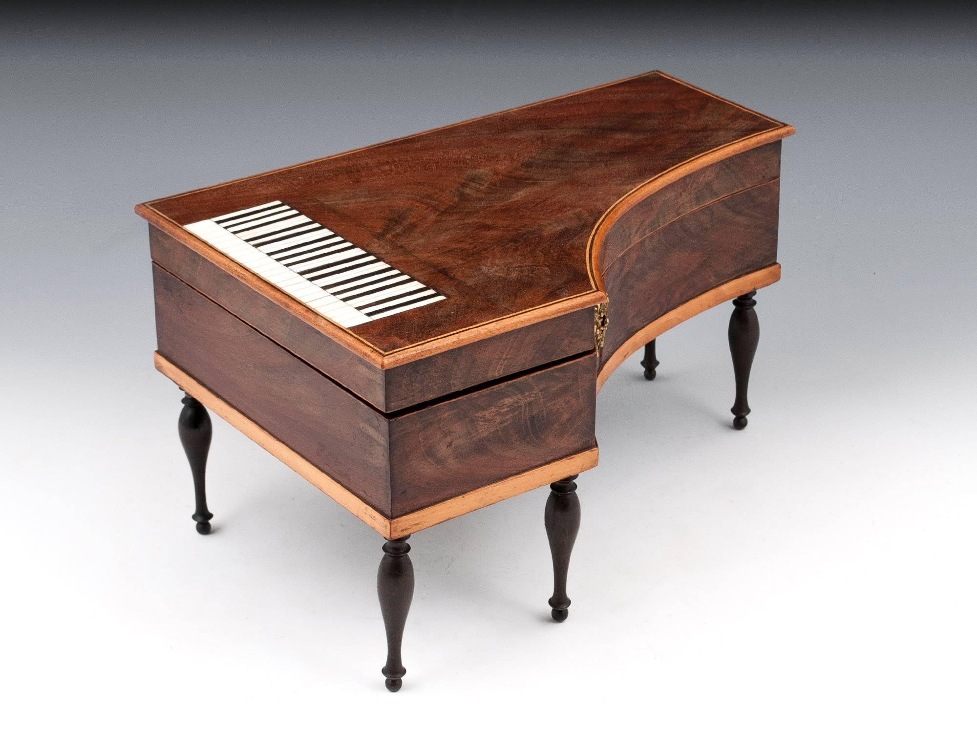 Antique Palais Royal mahogany sewing in the form of a miniature grand piano. The charming piano keys on the top of the box are made of ebony and bone, with the minor keys being slightly raised for an authentic look and feel. Standing on five turned
