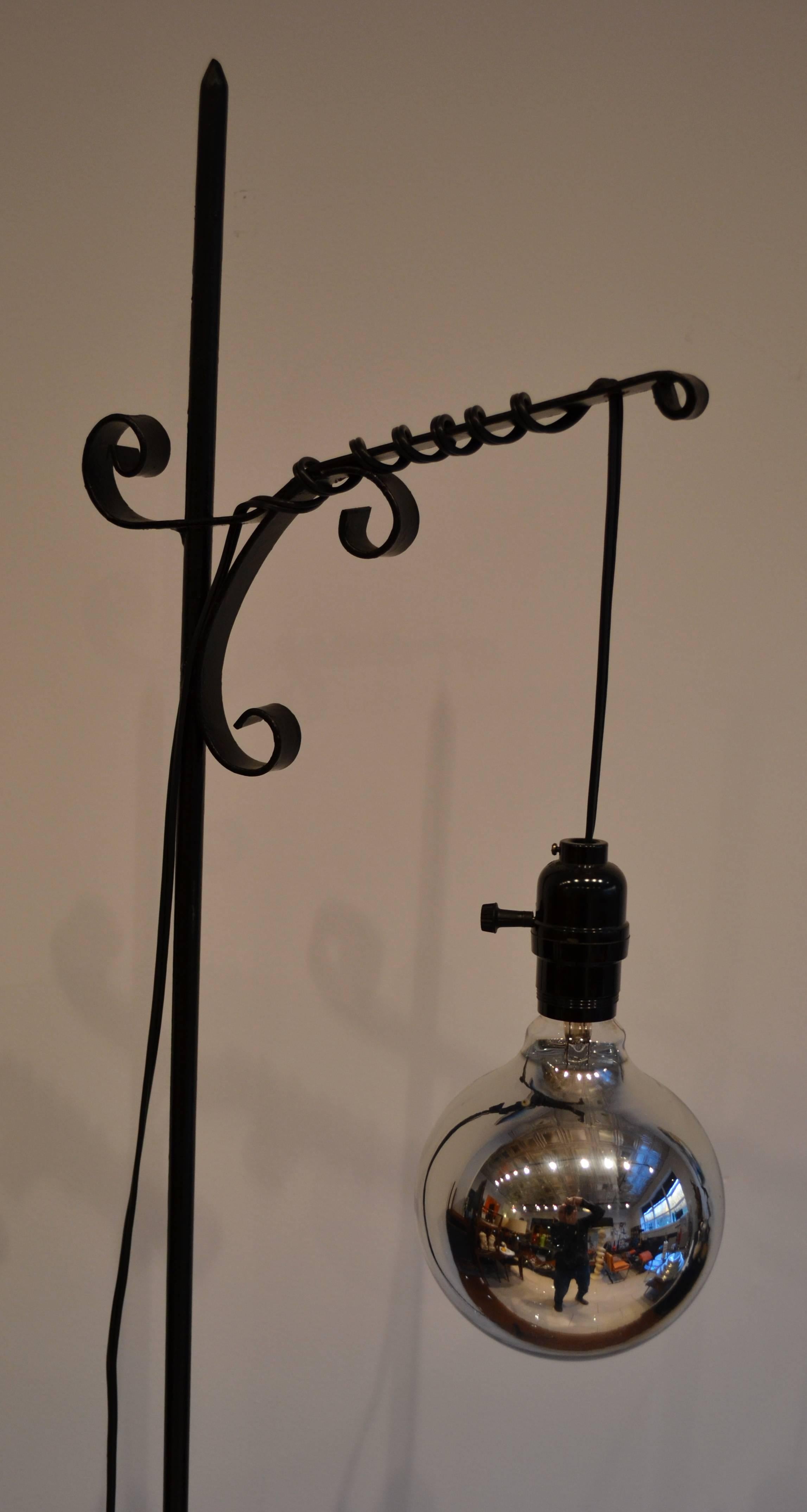 Lampada da terra molto bella con base in ferro battuto nero e lampadina a sospensione in argento al mercurio. Ricablata.