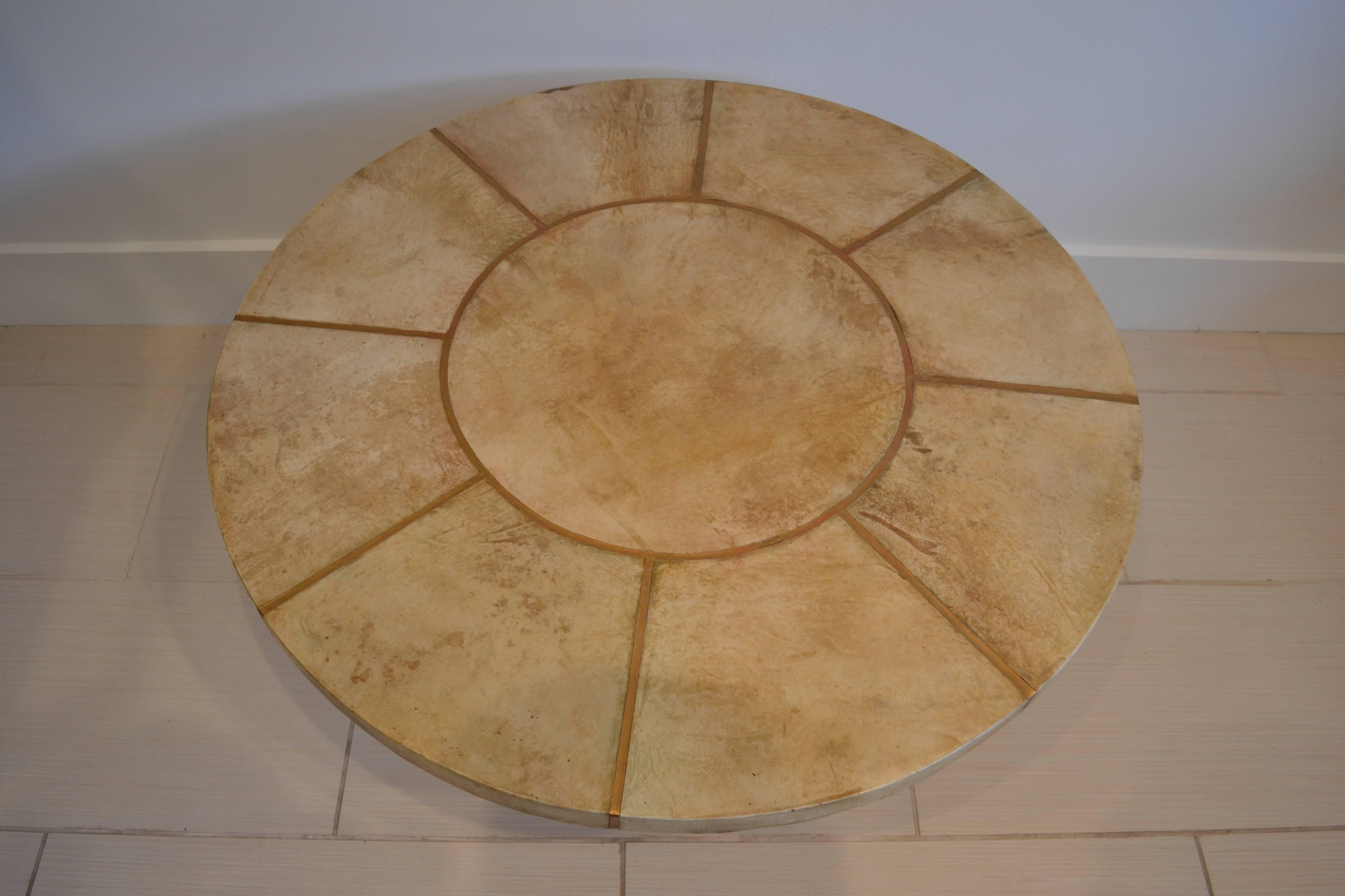 Round coffee table with goatskin top sectioned off with gold gilt iron. Gilded iron scrolled base, 1930s, French.