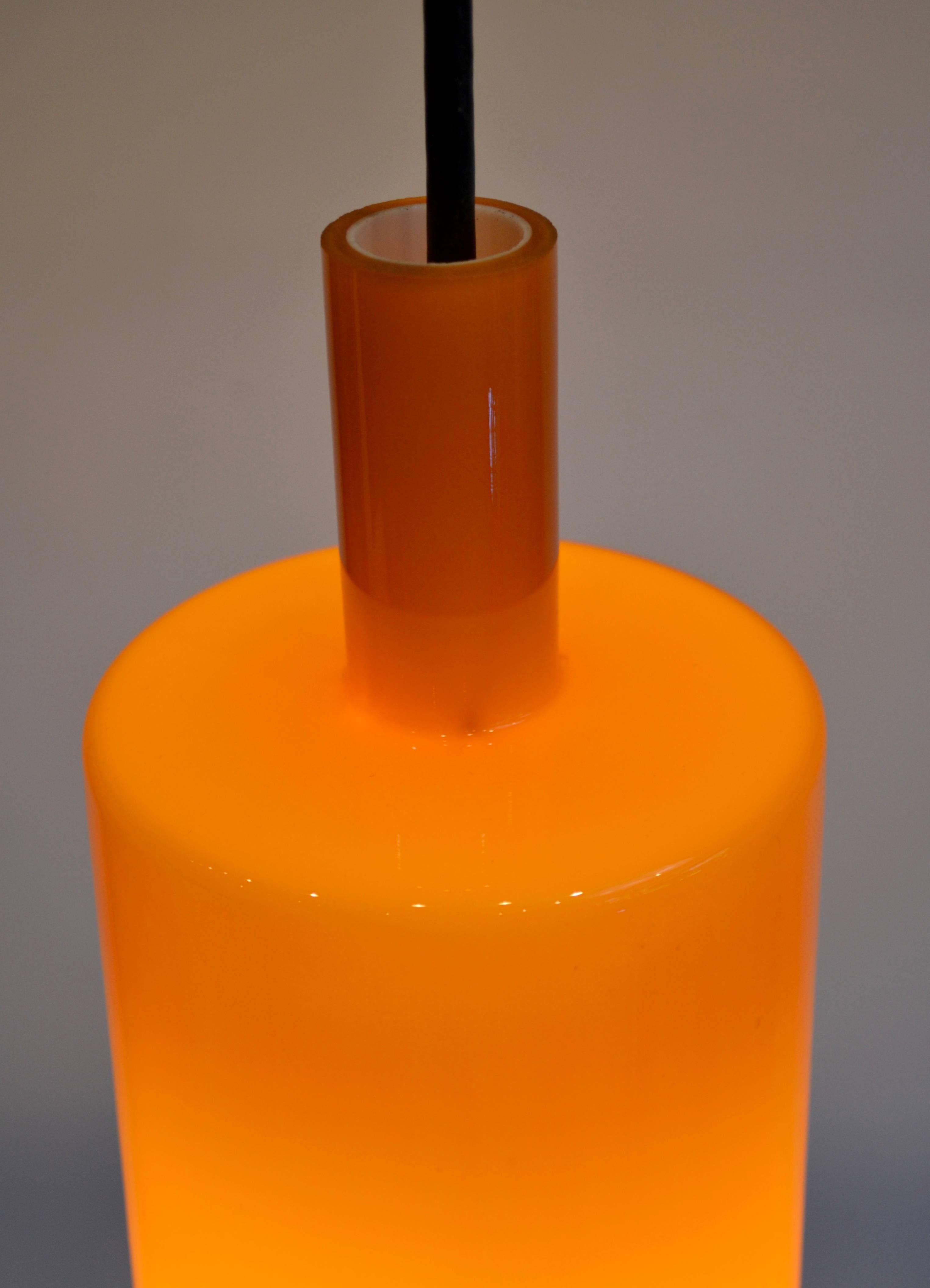 Gorgeous Danish orange glass pendant light designed by Jo Hammerborg for Fog and Mørup. In 1968 this light was shown in the catalogue of F and M. The glass has an opaline inside that spreads and softens the light.