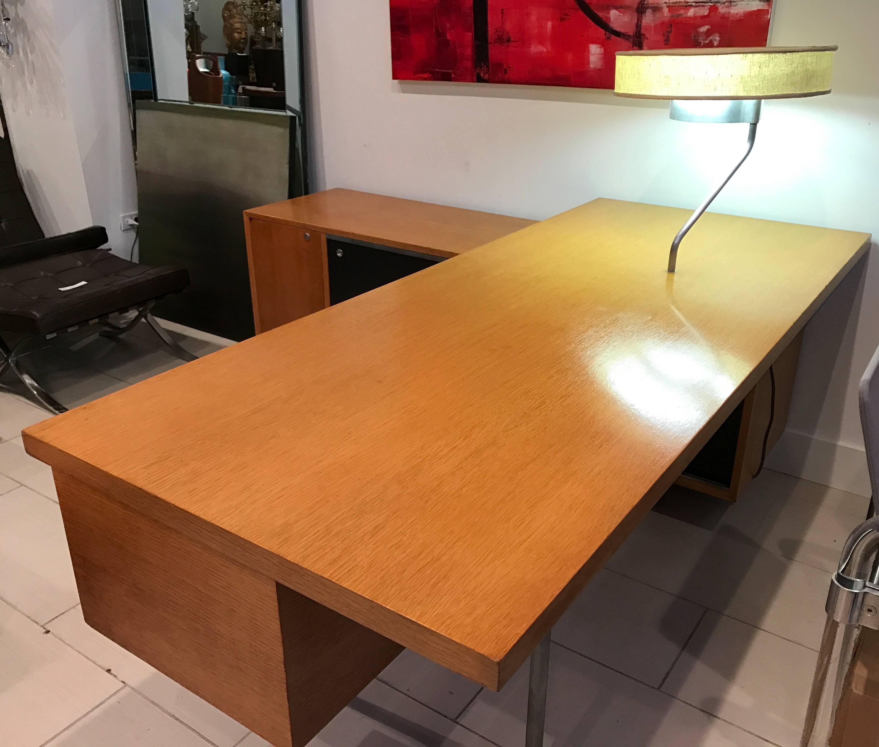 Exceptional George Nelson Executive Series desk with return credenza and attached desk lamp. Lamp works! Has original shade. The desk is attached to the credenza in an "L" shape. The credenza has access from both sides and features sliding