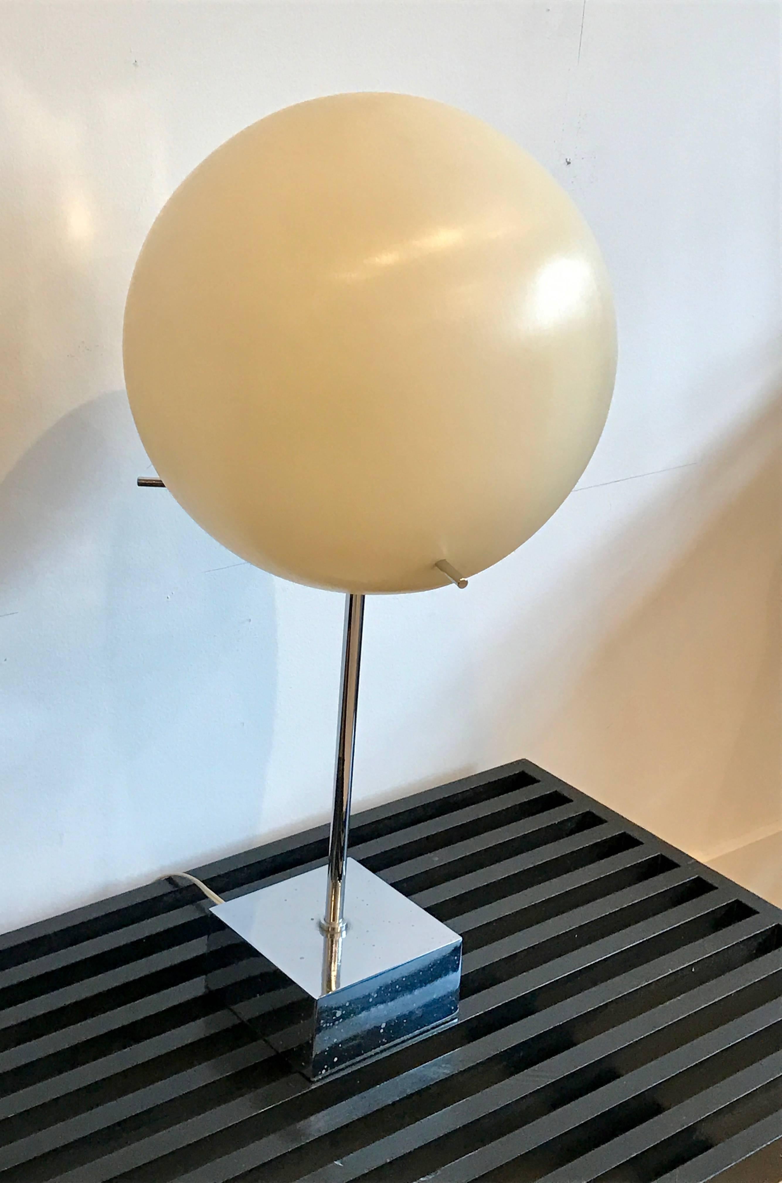 An ultra-modern chrome floor lamp with white globe shade by Paul Mayen for Habitat. Minimalist mirror-finish base and stem support an oversized balloon like plastic globe shade. A trio of chrome rods pierce the shade’s side, and serve as handles